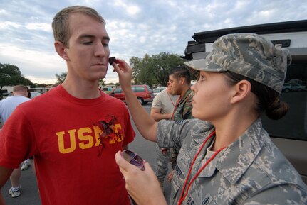 Staff Sgt. Julie Stewart, 12th Medical Group, applies "moulage" makeup to 2nd Lt. Scott Stepko, 562nd Flying Training Squadron, before an exercise scenario Sept. 16. On the heels of supporting the search and rescue mission for Hurricane Ike, Team Randolph members continued to demonstrate their level of readiness and attention to detail while conducting an explosion and hazardous materials exercise. (U.S. Air Force photo by Steve White.)
