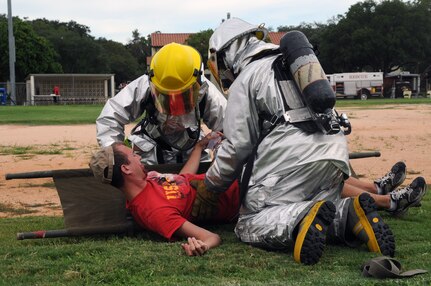 Fire department personnel load 2nd Lt. Scott Stepko, 562nd Flying Training Squadron, on a stretcher after a simulated bomb exploded Sept. 16, kicking off a hazardous materials exercise. On the heels of supporting the search and rescue mission for Hurricane Ike, Team Randolph members continued to demonstrate their level of readiness and attention to detail while conducting an explosion and hazardous materials exercise. (U.S. Air Force photo by Steve White.)