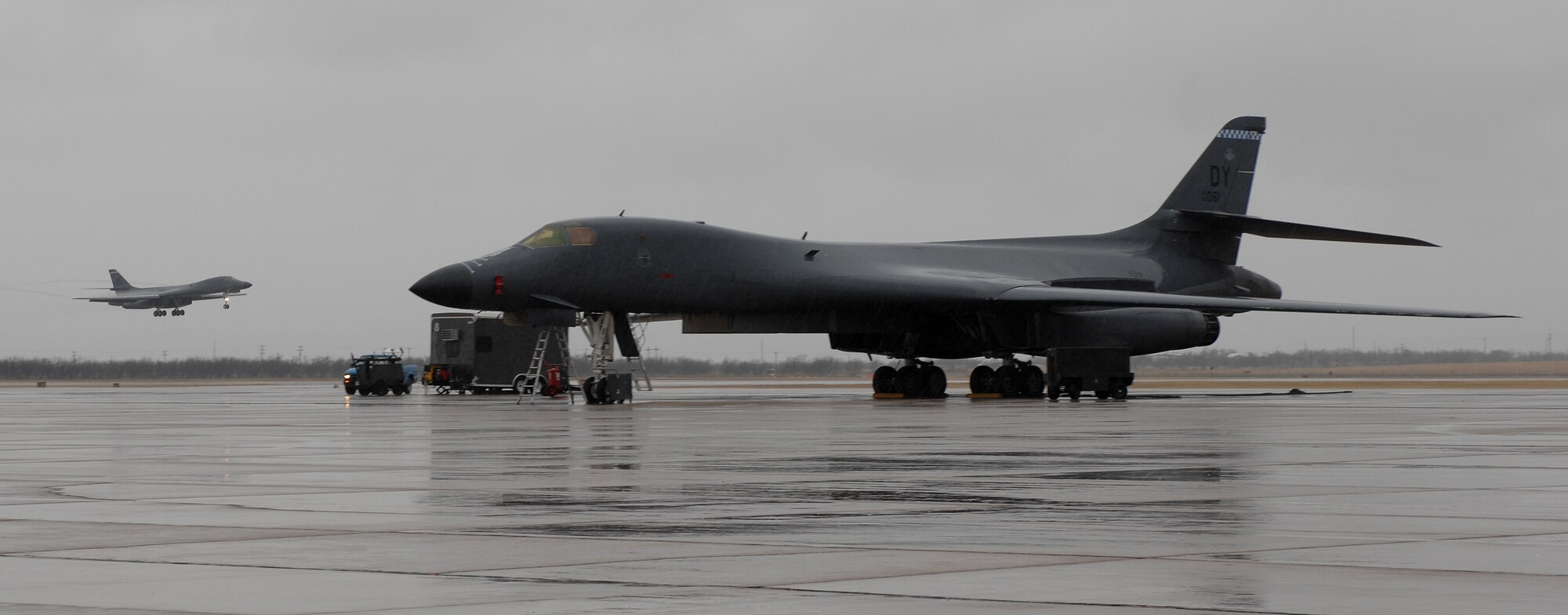 DYESS AIR FORCE BASE, Texas -- A B-1B Lancer lands while another B-1B prepares to take-off here, Mar. 18.  The B-1B Lancer is the first aircraft to fly at supersonic speed with a 50/50 blend of synthetic and petroleum fuel.  The 7th Operations Group has a vital role in completing the wing mission and ensuring the success of Team Dyess. (U.S. Air Force photo/Senior Airman Courtney Richardson)
