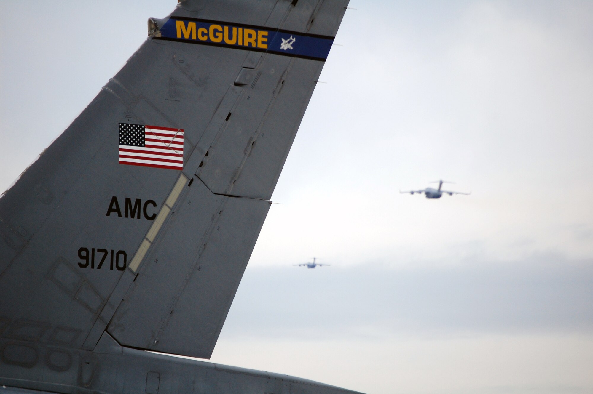 Two C-17 Globmaster IIIs climb into the sky behind the foreground view of a KC-10 Extender at McGuire Air Force Base, N.J., Sept. 16, 2008.  The KC-10 and the C-17 are some of the main aircraft airframes stationed at McGuire which help Air Mobility Command and the Air Force to "fly, fight and win...in air, space and cyberspace."  (U.S. Air Force Photo/Tech. Sgt. Scott T. Sturkol)