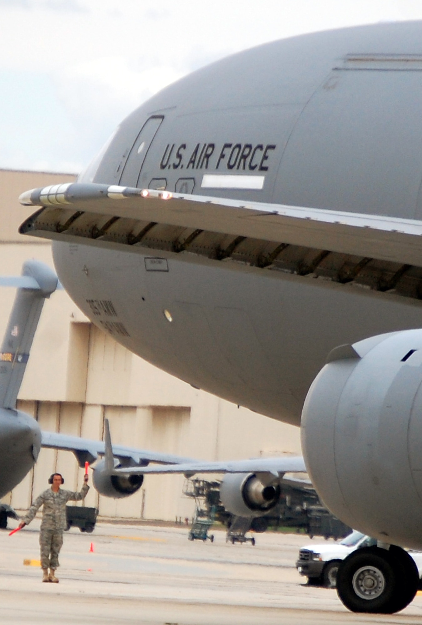 A maintenance crew chief for a KC-10 Extender provides direction to the aircrew steering a KC-10 on the McGuire Air Force Base, N.J., flightline Sept. 16, 2008.  The KC-10 is one of the main air refueling airframes at McGuire and helps Air Mobility Command and the Air Force to "fly, fight and win...in air, space and cyberspace."  (U.S. Air Force Photo/Tech. Sgt. Scott T. Sturkol)