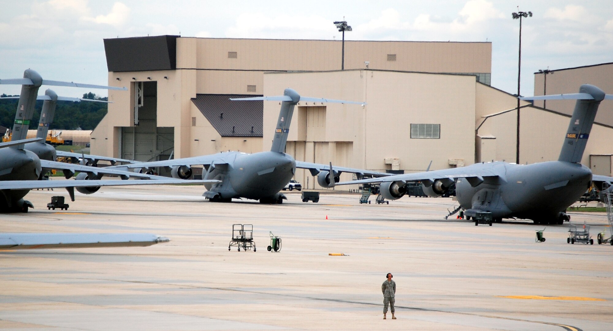 A maintenance Airman stands at parade rest on the McGuire Air Force Base, N.J., flightline during operations Sept. 16, 2008.  This Airman was watching the start-up of engines on a KC-10 Extender.  In the background there are several C-17 Globemaster IIIs that are also from McGuire.  (U.S. Air Force Photo/Tech. Sgt. Scott T. Sturkol)