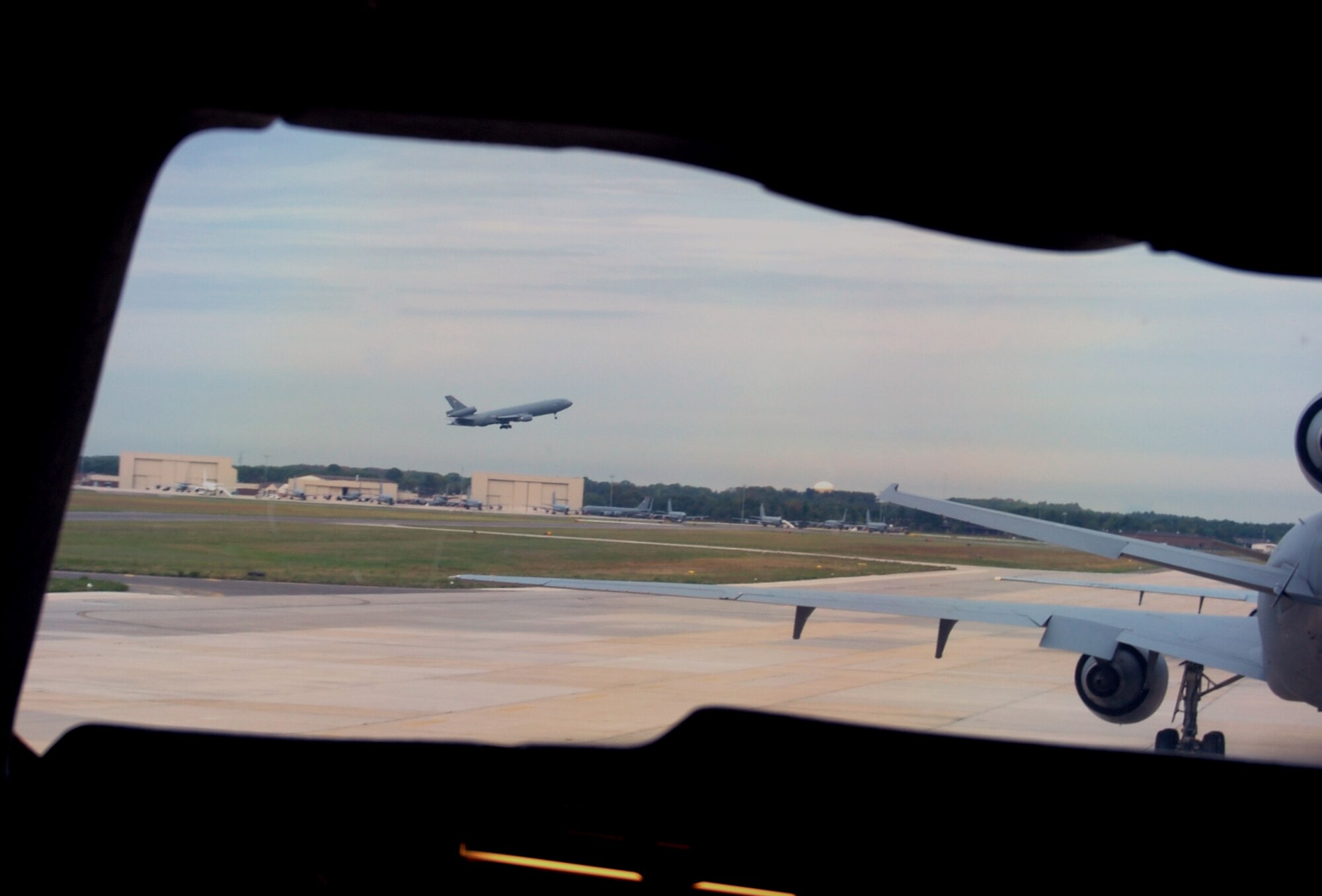 Through the flight deck window of  a KC-10 Extender, another KC-10 is seen taking off for a mission from McGuire Air Force Base, N.J., Sept. 16, 2008.  The KC-10 is one of the main aircraft types stationed at McGuire which helps Air Mobility Command and the Air Force to "fly, fight and win...in air, space and cyberspace."  (U.S. Air Force Photo/Tech. Sgt. Scott T. Sturkol)