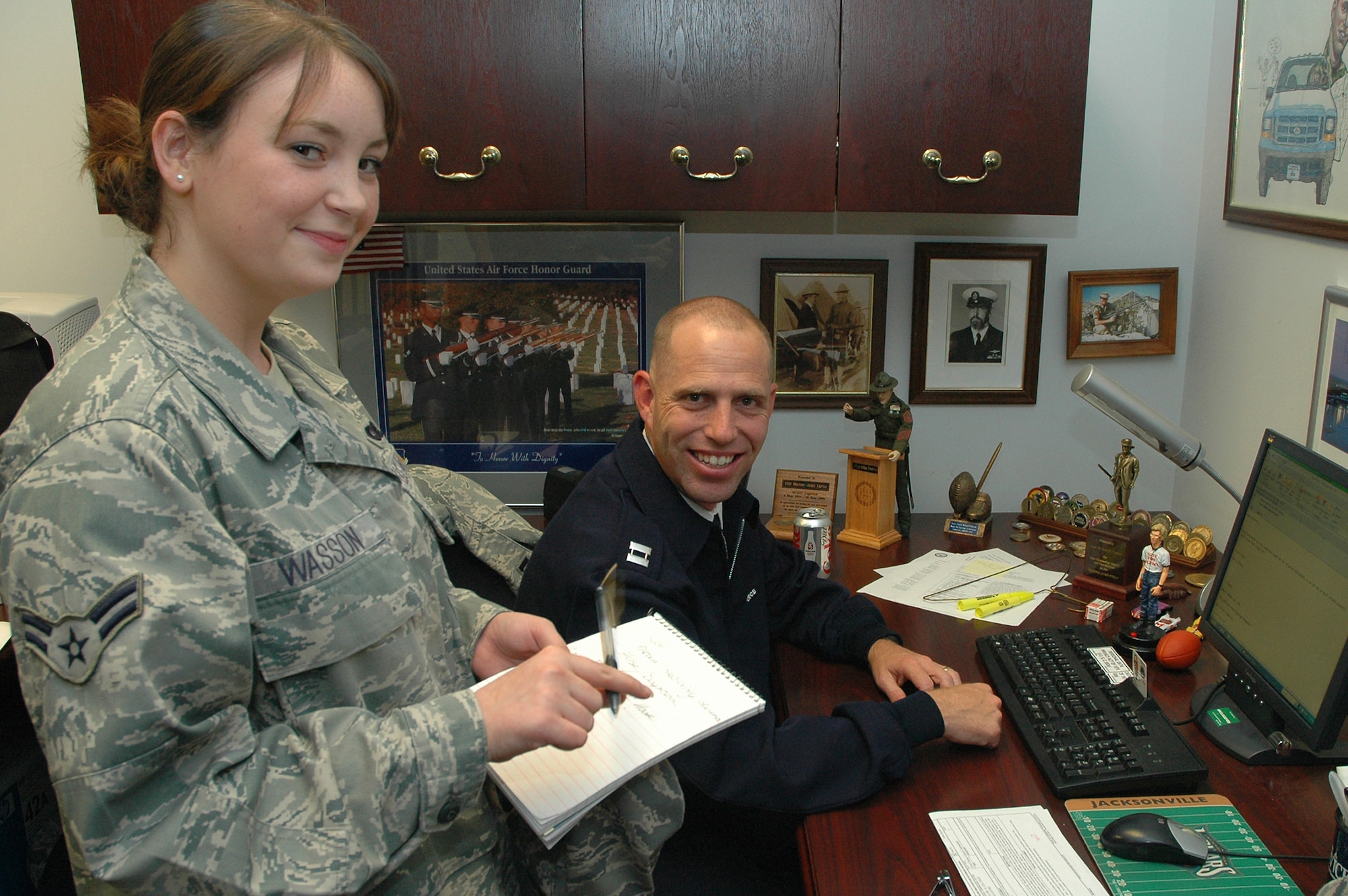 Airman 1st Class Anna M. Wasson, 11th Operations Group, speaks with Capt. Michael D. Fanton, U.S. Air Force Honor Guard, about creating e-mail accounts for incoming Airmen Sept. 16 at the Honor Guard complex. Airman Wasson was coined Sept. 15 during a wing stand-up by Col. Jon A. Roop, 11th Wing commander, for spearheading the validation of 450 network accounts and being named the 11th Wing Information Manager of the Quarter. (U.S. Air Force photo by Senior Airman Tim Chacon)