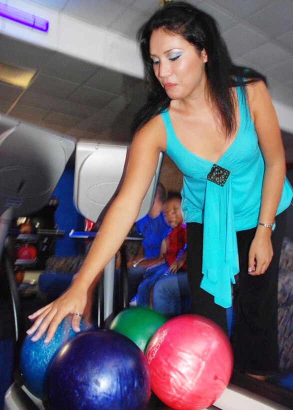 Senior Airman Kristin M. Cavander, 316th Security Forces Squadron entry controller, makes her selection from the ball return prior to taking her shot Sept 13. Cosmic Bowling is offered several times each month and features black light bowl and popular music.  The next Cosmic Bowl is Sept. 27.  (USAF photo by Airman Katie L. Justen)