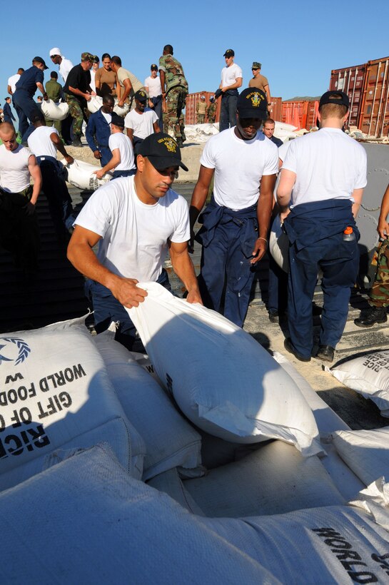 U.S. Navy Aviation Boatswains Mate Franklin Lopez, assigned to the USS Kearsarge, moves bags of rice from a landing craft during a humanitarian assistance mission in Haiti, Sept. 15, 2008. 