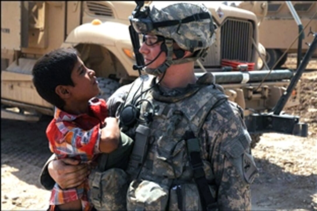 U.S. Army Staff Sgt. Robert Gray bonds with an Iraqi child during a patrol through Regular Six Park in the Sadr City district of Baghdad, Sept. 13, 2008. Gray and other soldiers are assigned to the 1st Battalion, 6th Infantry Regiment.
