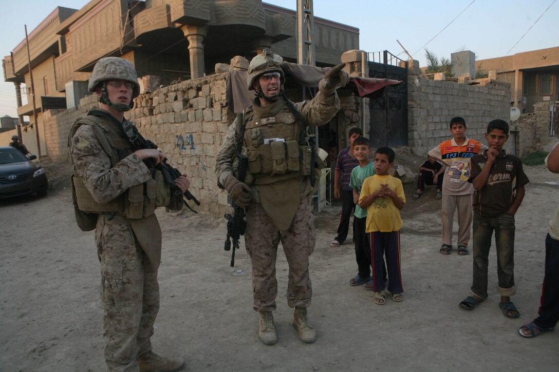 RAMADI, Iraq (September 19, 2008) - Petty Officer 3rd Class Benjamin Swain, left, a corpsman with 3rd Battalion, 11th Marine Regiment, Regimental Combat Team 1, and Maj. Jeffrey McCormack, the operations officer for 1st Battalion, 9th Marines, stand at the site where Benjamin's brother, James, was killed in 2004, Sept. 17.   “Benjamin was very grateful for the opportunity to see the actual area his brother was killed and the rooftop of the building where the pictures were taken,” McCormack said. "I don’t want to say it brought closure because the pain of losing a Marine never goes away. The loss of a brother will certainly never go away for Ben. I lost a Marine, but he lost a brother.”(Official U.S. Marine Corps photo by Lance Cpl. Casey Jones) (RELEASED)