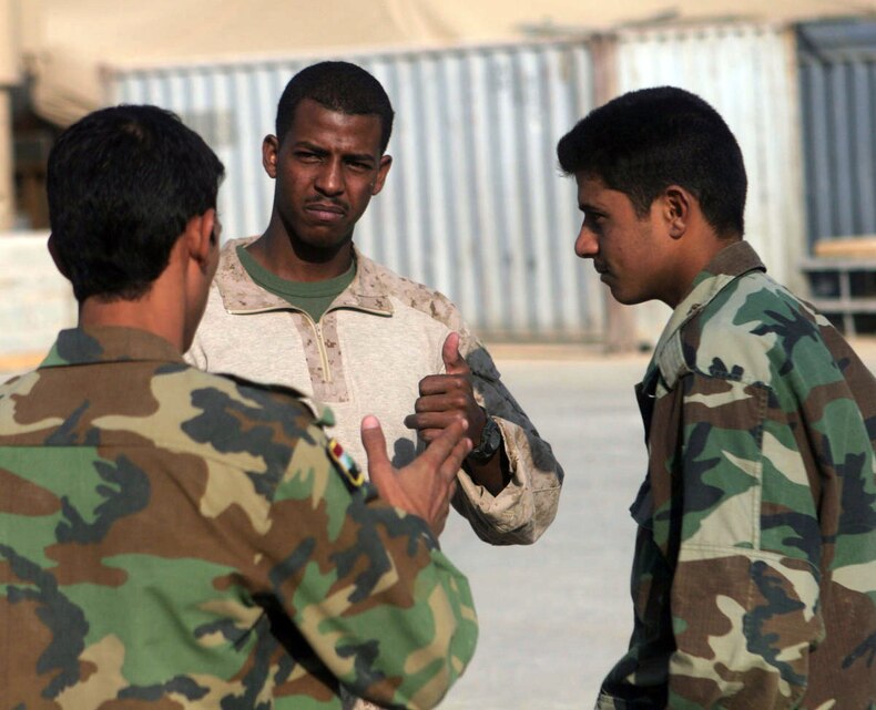 Lance Cpl. Migdad H. Mustafa, 21, from Sioux Falls, S.D., who is a combat engineer and Mine Resistant Ambush Protected vehicle driver with Jump Squad, Company A, 3rd Combat Engineer Battalion, Regimental Combat Team 5, speaks with several Iraqi Army engineers in al-Anbar province, Iraq, Sept. 17. Mustafa was born in Sudan and is able to speak fluent Arabic, which has been a valuable asset for his unit during their current deployment to Iraq. Mustafa is often able to gather intelligence from the locals and able to help out his fellow Marines by acting as their interpreter. ::r::::n::
