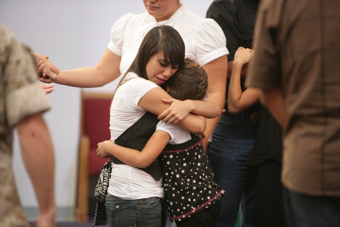 Makayla, daughter of Pfc. Ernie Villarreal, infantry weapons repairman with 1st Tanks, hugs her aunt during her father’s memorial service Sept. 18. Villarreal, 27, is an El Paso, Texas, native, who died Sept. 16 at Robert E. Bush Naval Hospital.