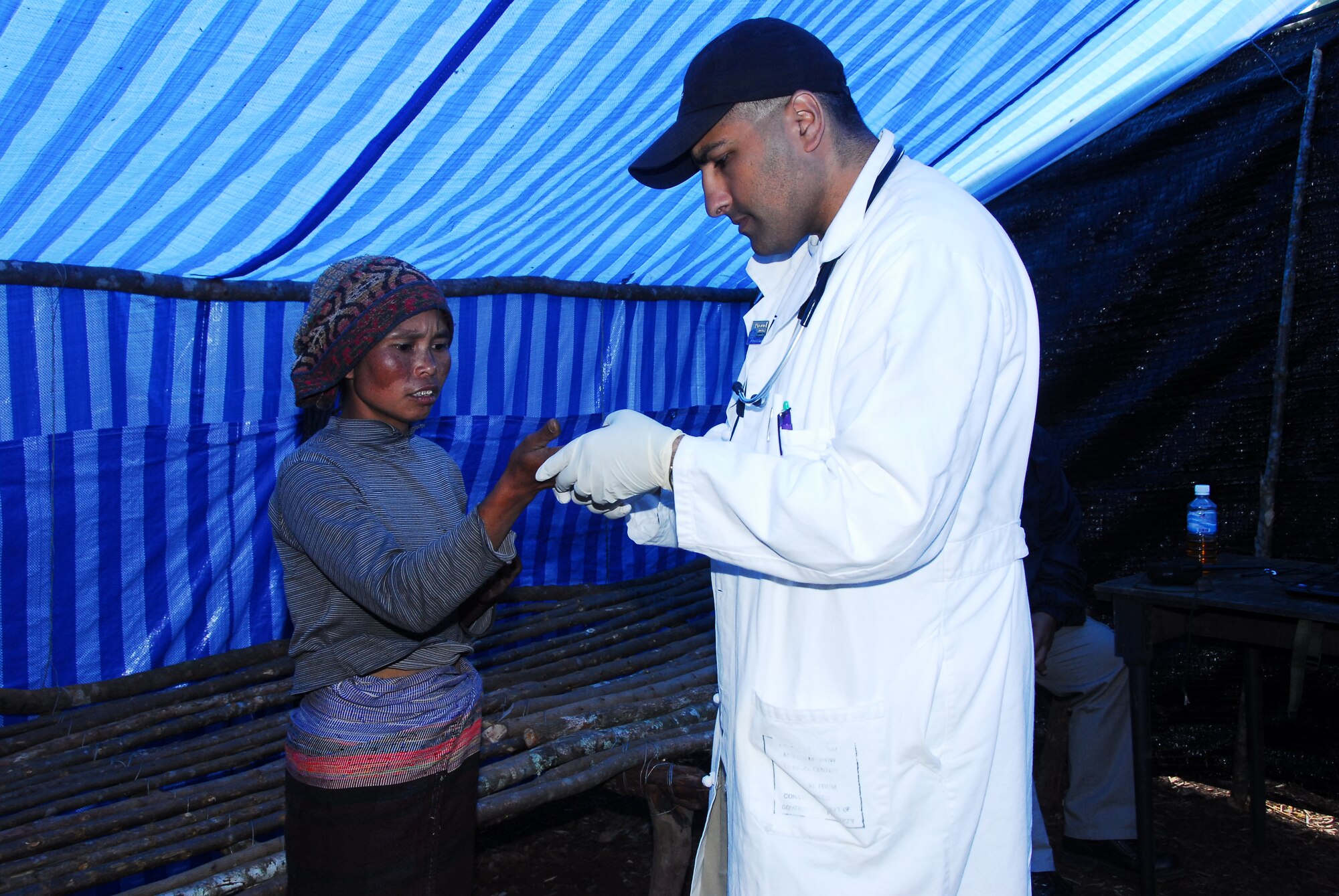 Maj. (Dr.) Aasif Mirza, 18th Medical Operations Squadron, examines a Laotian
patient May 9 as part of a medical civic action project during a Joint
POW/MIA Accounting Command mission in Laos.  (JPAC photo/Staff Sgt. Valda G. Wilson)