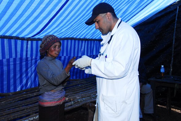 Maj. (Dr.) Aasif Mirza, 18th Medical Operations Squadron, examines a Laotian
patient May 9 as part of a medical civic action project during a Joint
POW/MIA Accounting Command mission in Laos.  (JPAC photo/Staff Sgt. Valda G. Wilson)