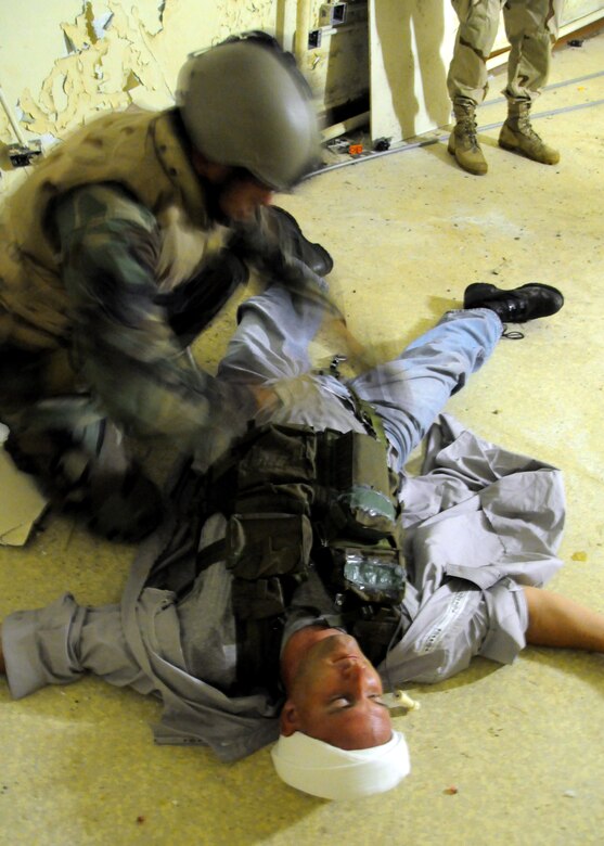 ANDERSEN AIR FORCE BASE, Guam - Staff Sgt. Jonathon Young, 36th Mobility Response Squadron, explosive ordnance disposal specialist, removes a simulated suicide bombers shirt at TRICRAB '08. The 24-hour multinational, joint-service explosive ordnances disposal exercise held Sept. 14-18. Teams representing the U.S. Air Force, U.S. Navy, Royal Australian Air Force and Royal Australian Navy set up tents on a simulated forward operating base at Andersen South with perimeter and site security by the U.S. Army National Guard Guam. The joint-forces conducted scenarios on Andersen South, Northwest Field and Naval Base Guam. (U.S. Air Force photo by Airman 1st Class Nichelle Griffiths)