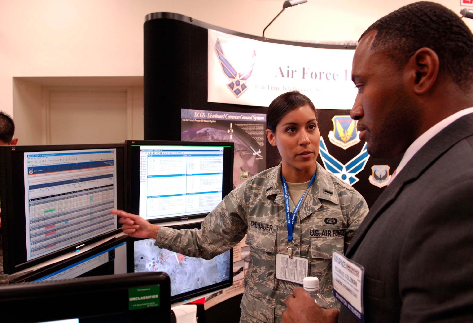 WASHINGTON -- 2nd Lt. Maraline Cronauer, 497th Intelligence Group, 480th Intelligence Wing at Langley Air Force Base points out features of the Distributed Common Ground System to visitor Richard Coleman during the Air Force Association’s 24th Annual Air and Space Conference and Technology Exposition Sept. 16. A hundred and twenty-five Langley Airmen attended the event. (U.S. Air Force photo/Airman Rebecca Montez)
