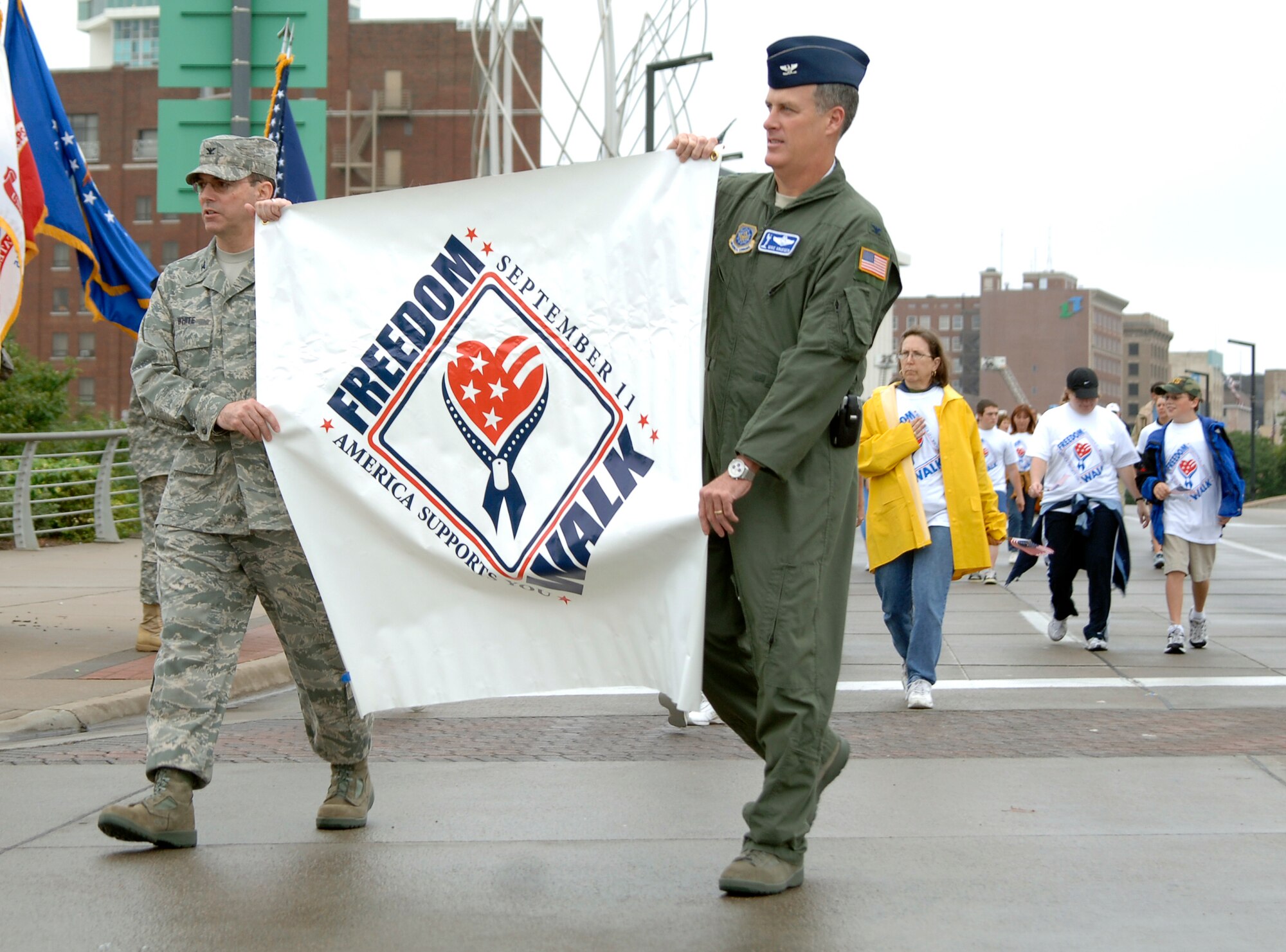MCCONNELL AIR FORCE BASE, Kan. -- Col. Mark White, 22nd Mission Support Group commander, and Col. Michael Krueger, 22nd Air Refueling Wing vice commander, carry the first Wichita “America Supports You” Freedom Walk banner in downtown Wichita, Sept. 13.  This event is a time for people to reflect on the lives lost during the 9/11 attacks. (Photo by Staff Sgt. Ronald Lafosse)