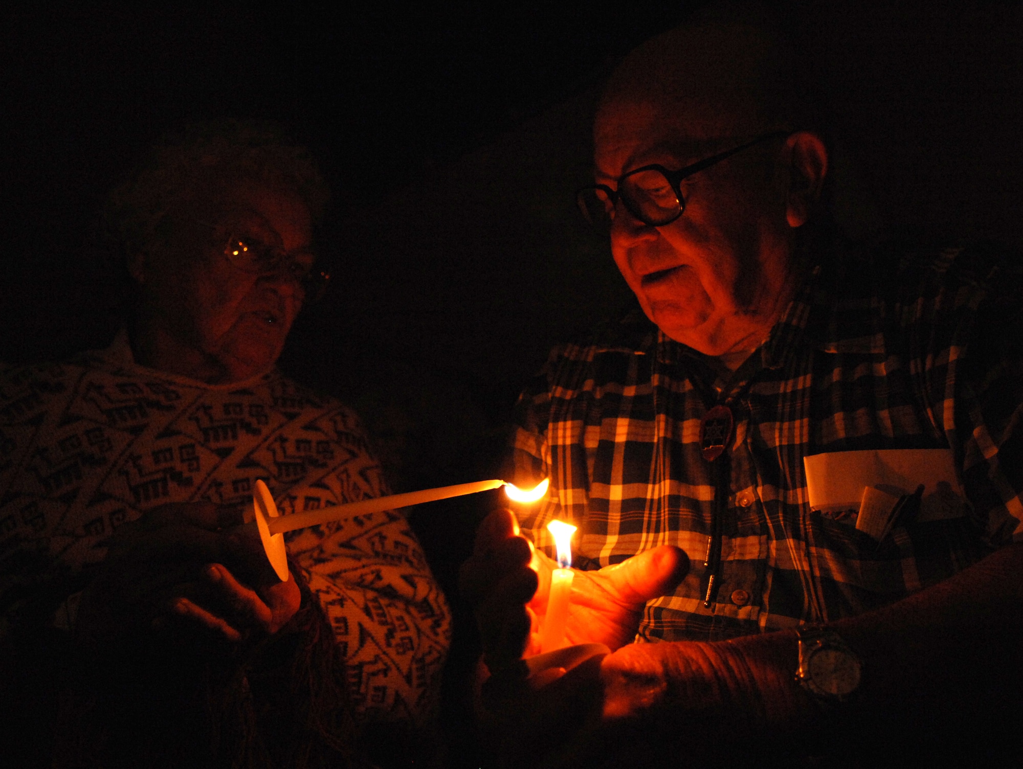 Norris Bergstrom lights his wife, Jean?s, candle during the candle-lighting at the seventh annual 9/11 Memorial Ceremony at the New Mexico Museum of Space History, September 11. The event was put together by the Fire Department of Holloman Air Force Base, N.M., and the Otero County Firefighters Assocation. (U.S. Air Force photo/Airman Sondra M. Escutia)