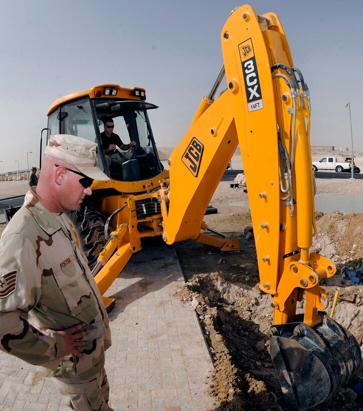 Tech. Sgt. Jason Foster provides an extra set of eyes for Staff Sgt. David Bengate, who operates the backhoe, clearing dirt from a broken section of water main Sept. 15 at a Southwest Asia air base. The broken pipe caused a loss of water for the entire Blatchford-Preston Complex here. Sergeant Foster hails from Perrysburg, Ohio and is deployed from Scott Air Force Base, Ill. Sergeant Bengate, a native of Cadillac, Mich., is deployed from McConnell AFB, Kan. Both are assigned to the 379th Expeditionary Civil Engineer Squadron. (U.S. Air Force photo/Tech. Sgt. Michael Boquette) 