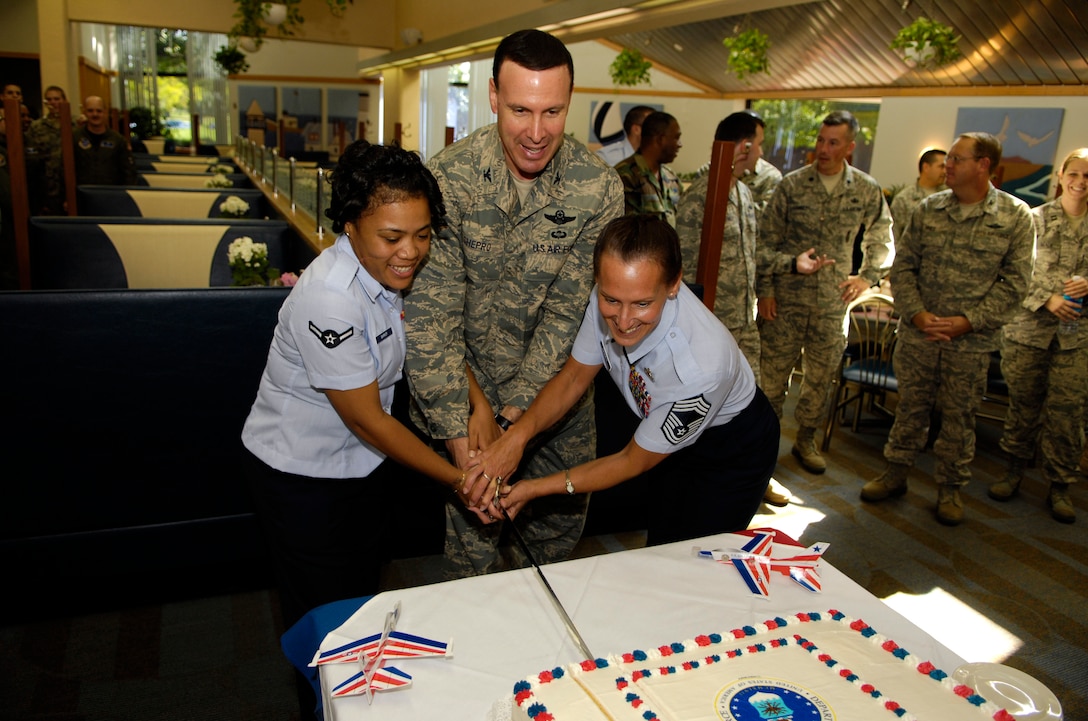 Col. Steven Shepro (center), 316th Wing commander, along with Airman Tiffany Barker (left), 316th Operations Support Squadron, and Chief Master Sgt. Lisa Haggett, 316th Force Support Squadron Superintendent, cut a birthday cake at the Freedom Hall Dining Facility Thursday. September 18 commemorated the Air Force’s 61st birthday. Airman Barker is the newest Airman on Andrews, while Chief Haggett is Andrews’ most seasoned career Airman. (USAF photo by Senior Airman Steven R. Doty)