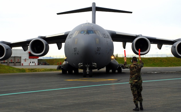 Kevin McElhoes, a C-17 crew chief with the 176th Wing's 249th Airlift Squadron, guides a Mississippi Air National Guard C-17 onto the flightline at Kulis Air National Guard Base, Alaska on Sept. 17, 2008. The C-17 Globemaster III carried two PaveHawk helicopters and their crews from the wing's 210th Rescue Squadron; and a group of pararescuers from the wing's 212th Rescue Squadron. The wing members deployed to the Gulf Coast region Sept. 1 to perform search-and-rescue operations in the aftermath of hurricanes Gustav and Ike. They were credited saving 16 lives during the mission.
