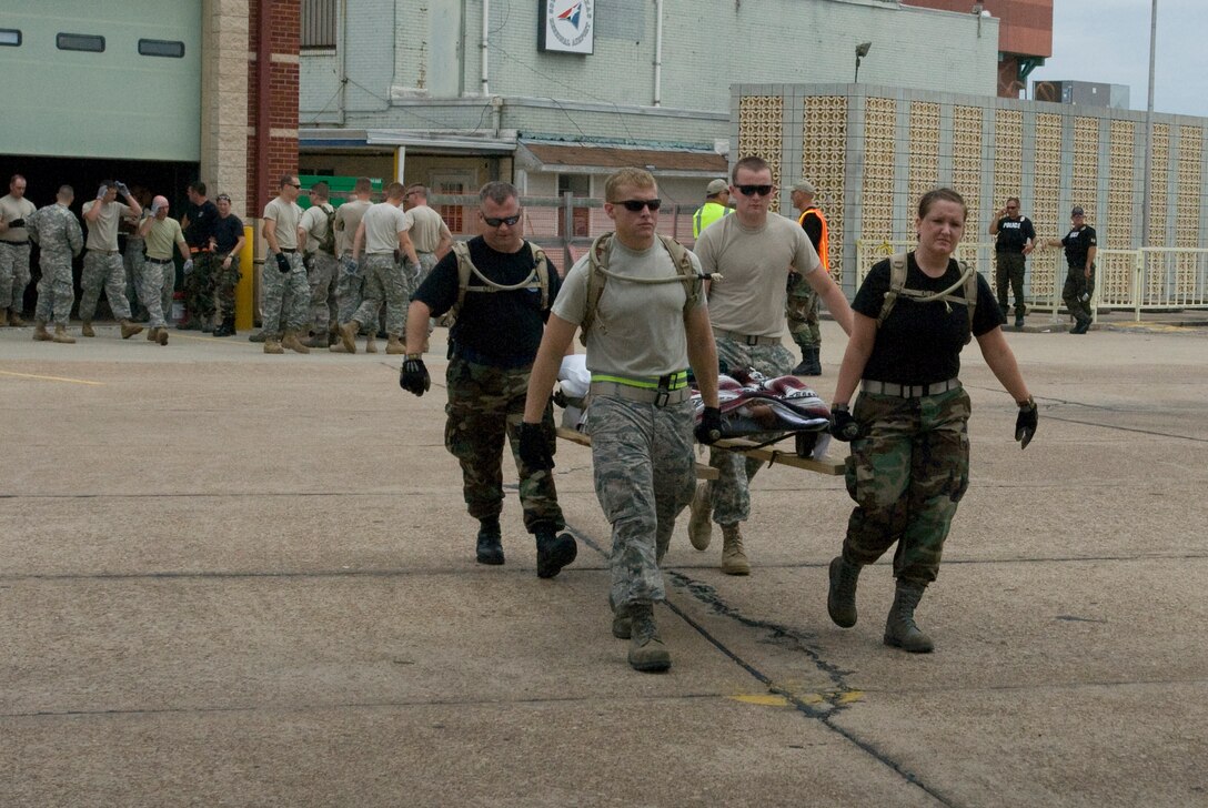 U. S. Air Force unit members from the 136th Airlift Wing, Texas Air National Guard, Fort Worth carry a special needs person awaiting to airlift to safety at the SE Texas Regional Airport, Beaumont , Texas, in support of Hurricane Ike relief efforts, 11 September 2008. (Photo by Staff Sgt Jennifer Marrs)