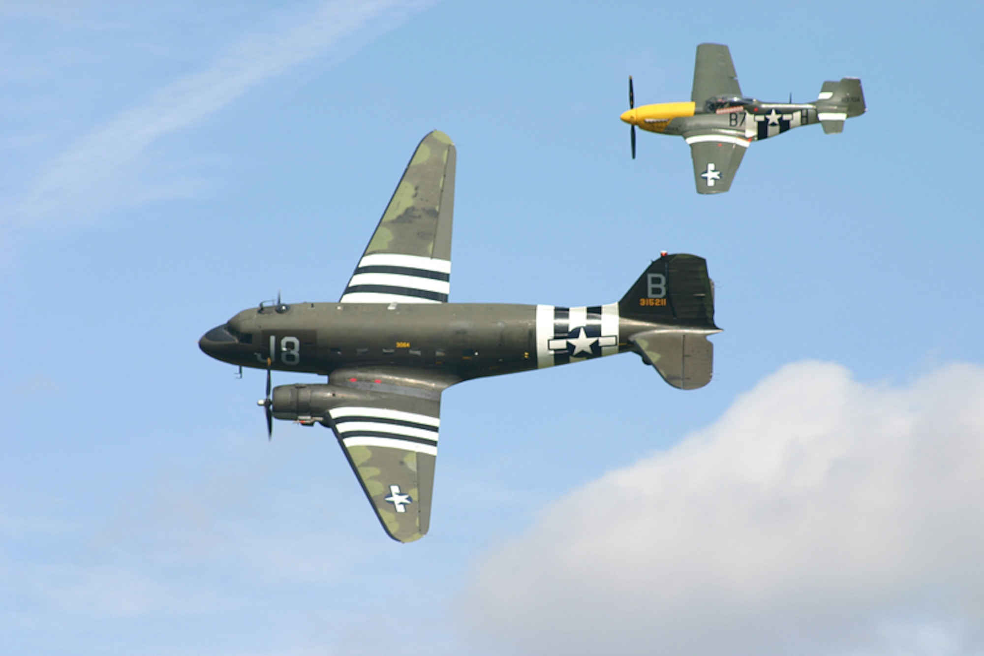 An American C-47 flies with a fighter escort during Operation Market Garden 2008.  Operation Market Garden was a two day event held to honor WWII veterans that were stationed at RAF Spanhoe, England. (U.S. Air Force courtesy photo)