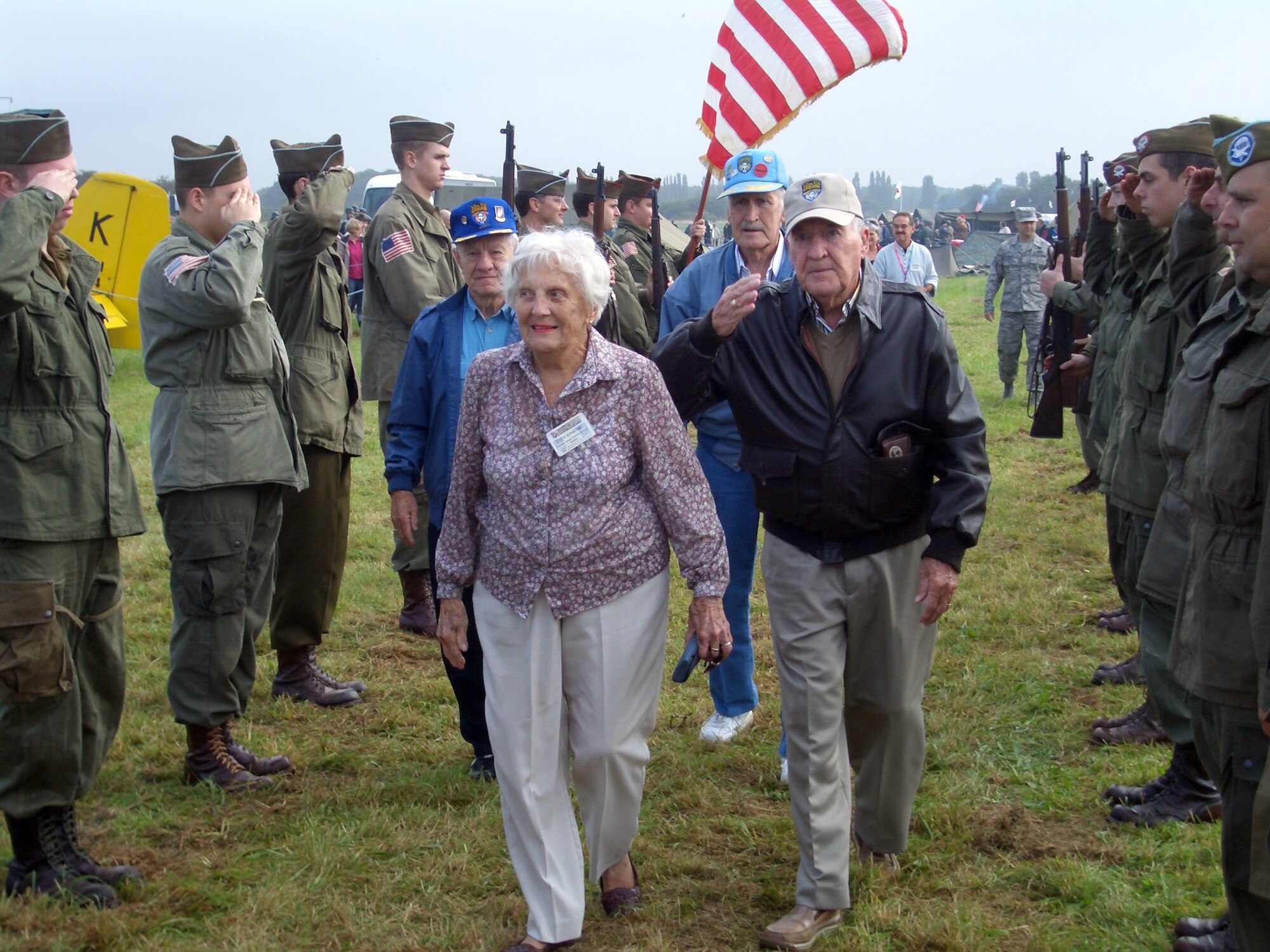 Dick Ford, Evelyn "Chappy" Kowalchuk, Bernie Brown and Bud Pence, all veterans of the 315th Troop Carrier Group stationed at RAF Spanhoe during WWII, walk through an honor guard comprised of British re-enactors at the start of Operation Market Garden.  Operation Market Garden was a two day event held to honor the veterans who were stationed here. (U.S. Air Force photo/Capt. Wayne Capps)