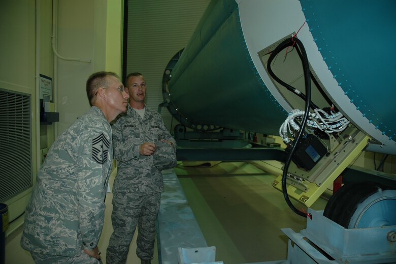 Air Force Space Command Chief Master Sgt. Todd Small (left) examines a Delta II booster being readied for launch in the Missile Checkout Facility on Cape Canaveral Air Force Station Sept. 11 as Tech. Sgt. Will McCormick describes the system.