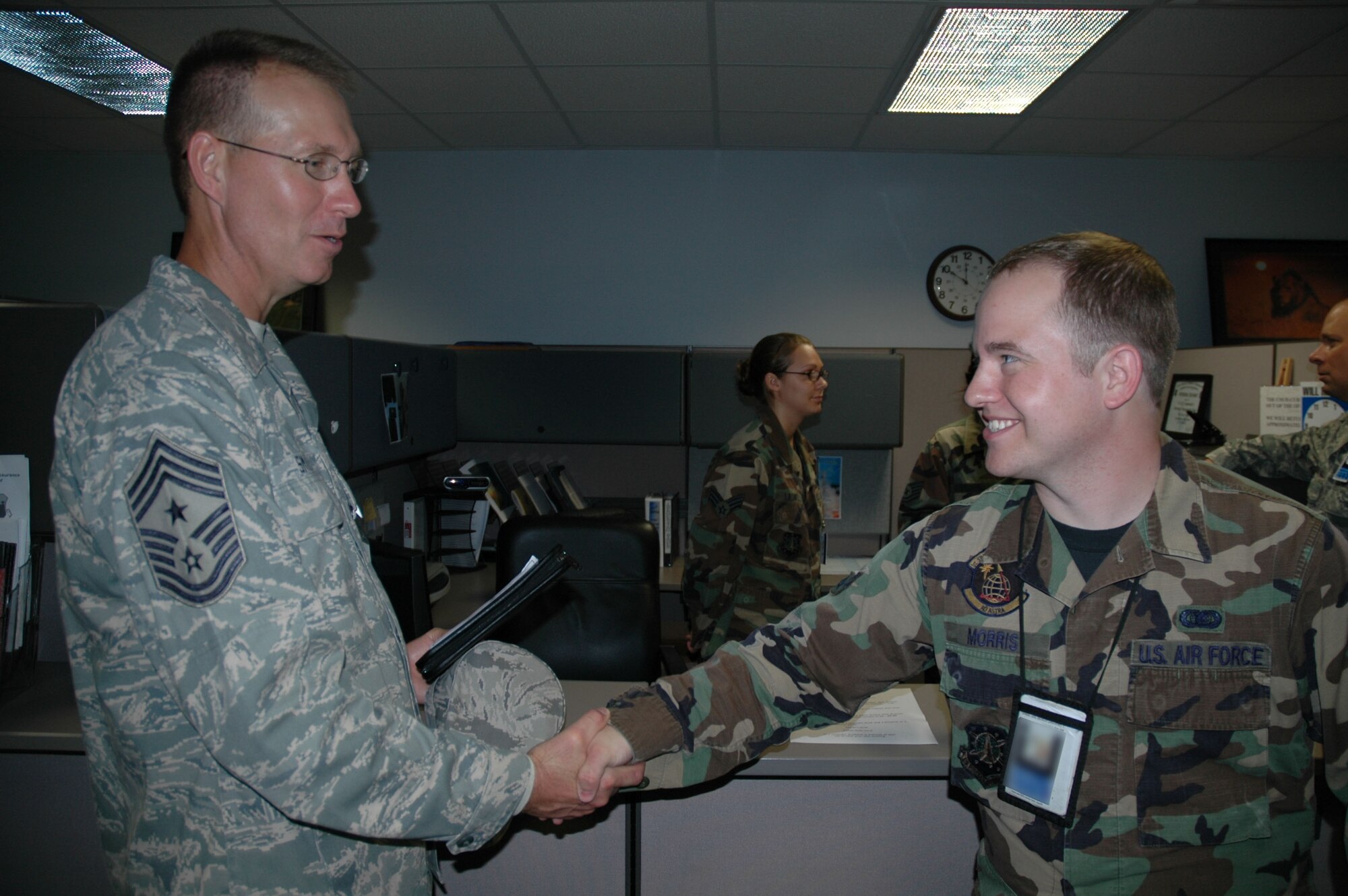 Air Force Space Command Chief Master Sgt. Todd Small shakes hands with Airman of the Quarter Airman 1st Class Eric Morris in the 45th Launch Group Headquarters during Chief Small's visit to Cape Canaveral Air Force Station Sept. 11. (U.S. Air Force photo by Airman 1st Class David Dobrydney)