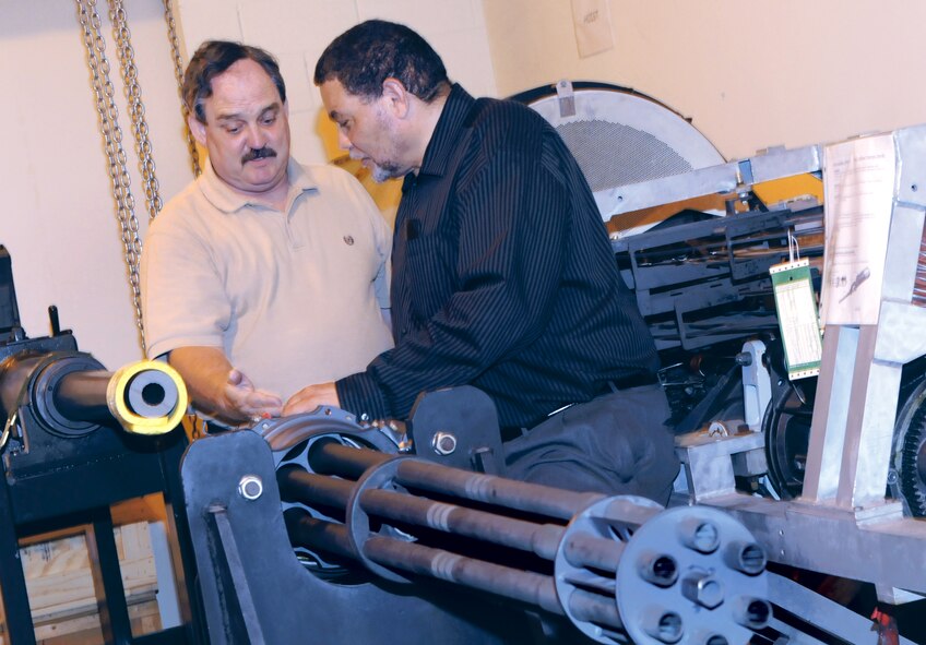 Tim Yancy, 575th CBSS fighter bomb rack equipment specialist, and Ron Ryan, 575th CBSS configeration management specialist, inspect a M61A1 20 MM gun used on the F-15, F-16, and F-22 in the Air Force Gun Lab here at Robins. U. S. Air Force photo by Sue Sapp