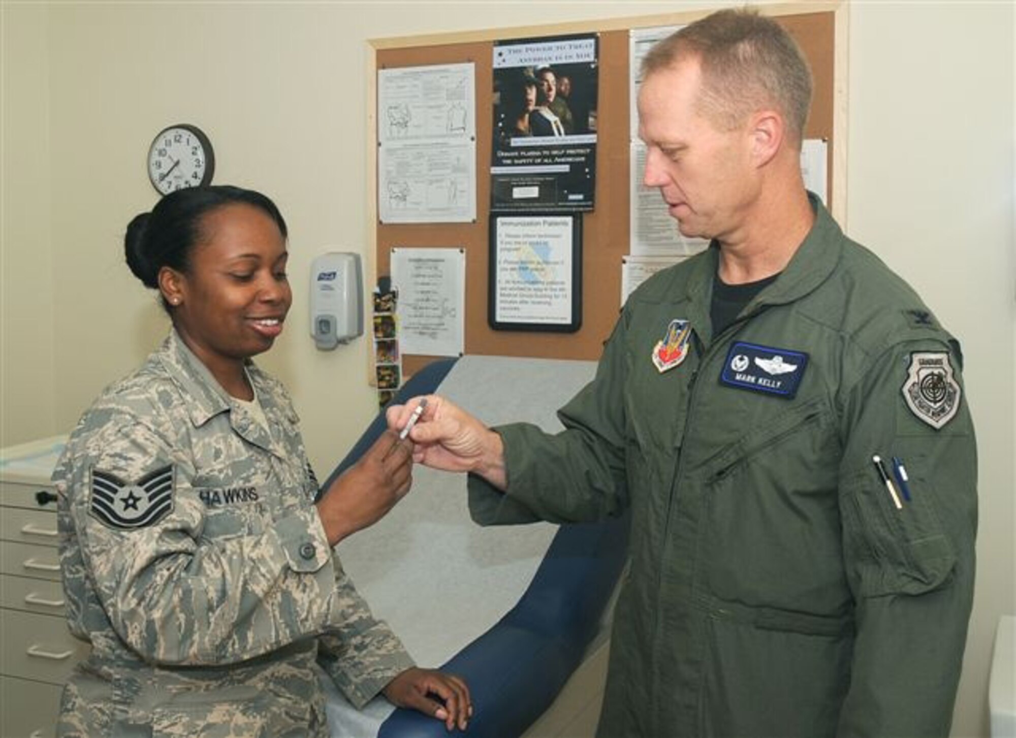 TSgt Patrenia Hawkins, immunization technician, 4th Medical Squadron, speaks with Col Mark Kelly, 4th Fighter Wing Commander, on how to administer the flu mist Sept 8. U.S. AIr Force photo by Staff Sgt Jessica Klingler