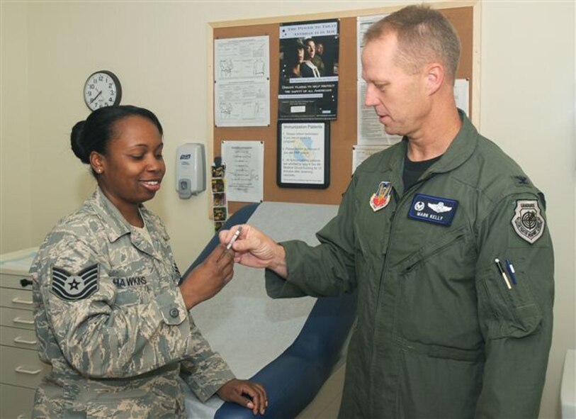 Tech. Sgt. Patrenia Hawkins, an immunization technician from the 4th Medical Group, speaks with 4th Fighter Wing commander Col. Mark D. Kelly prior to administering the flu mist vaccine Sept. 8. The flu prevention program begins Sept. 22. Immunization teams will visit active-duty work centers. The flu mist vaccine is available to all healthy, non-pregnant personnel, ages 2-49. Those outside this range or with other limiting factors may receive the flu shot, if appropriate. (U.S. Air Force photo by Staff Sgt. Jessica Klingler)