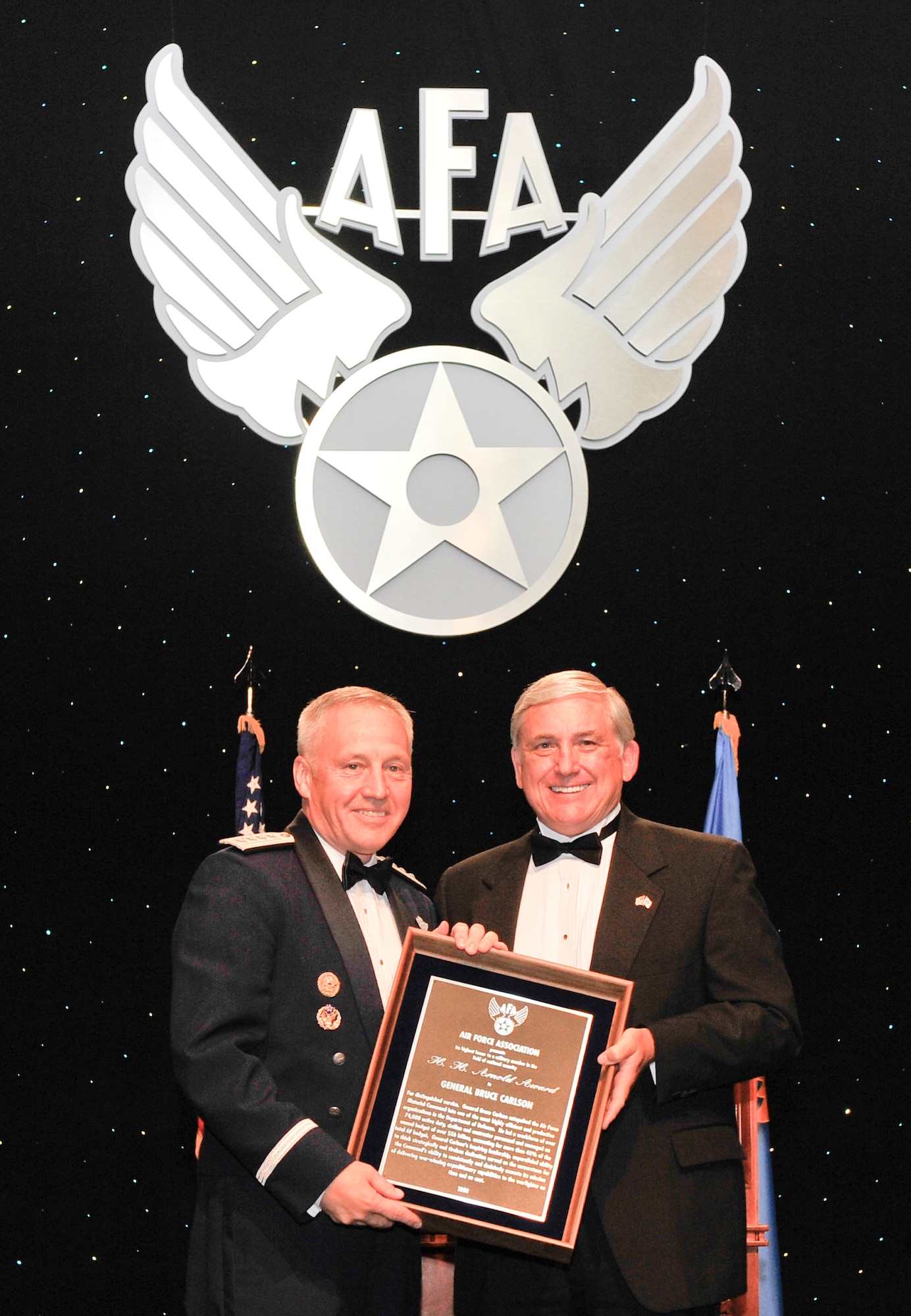 Gen. Bruce Carlson, commander of Air Force Materiel Command, receives the H. H. Arnold award from Air Force Association chairman Robert Largent Sept. 17 at the Marriott Wardman Park Hotel in Washington, D.C.  AFA hosted its 24th annual Air & Space Conference and Technology Exposition Sept. 15-17. (Air Force photo by Michael Pausic)