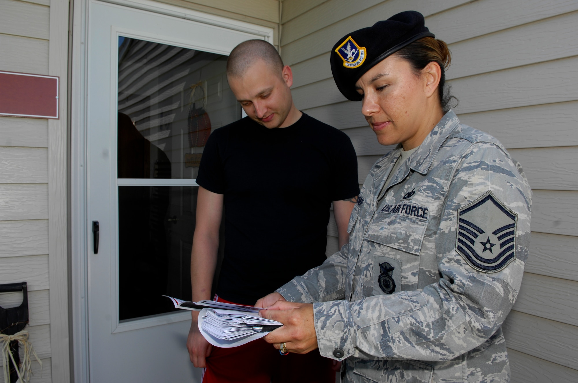 MINOT AIR FORCE BASE N.D. -- Master Sgt. Yuvonne Fischer (right), 5th Bomb Wing anti-terrorism officer, discusses the Neighborhood Sensor Program with Staff Sgt. Derek Buss (left), 91st Missile Wing facility manager trainer, here Sept. 16. The program is designed to help the 5th Security Forces Squadron keep the base safe and secure by asking residents to report any suspicious activity to the base law enforcement desk. (U.S. Air Force photo by Senior Airman Joe Rivera)