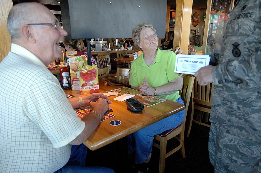 MINOT, N.D. – Minot locals Elain and Dick Kittell take a few minutes to listen to Airman 1st Class Jake Harris, 5th Security Forces Squadron at Minot Air Force Base, as he explains how the “Tip-a-Cop” fundraising program helps raise money for Special Olympics. The goal of the “Tip-a-Cop” program is for law enforcement officers to collect as many “tips” or donations as possible for Special Olympics. (U.S. Air Force photo by Senior Airman Kelly Timney)