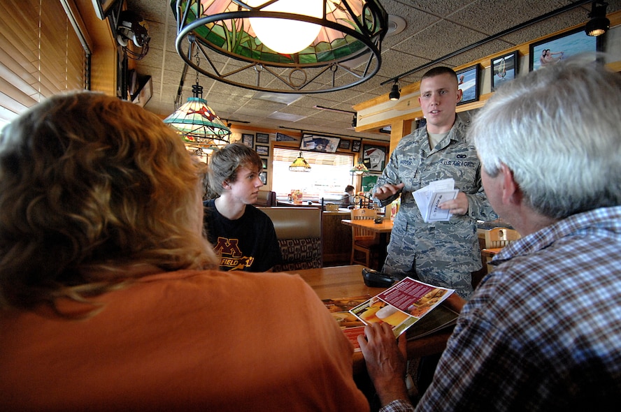 MINOT, N.D. – Airman 1st Class Jake Harris, 5th Security Forces Squadron at Minot Air Force Base, explains the mission of the “Tip-a-Cop” fundraising program to a family eating at the Minot Applebee’s Restaurant here Sept. 15. The goal of the “Tip-a-Cop” program is for law enforcement officers to collect as many “tips” or donations as possible for Special Olympics. (U.S. Air Force photo by Senior Airman Kelly Timney)
