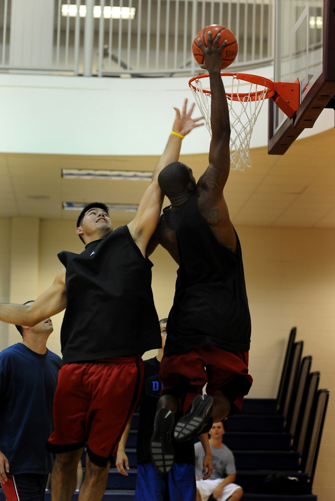 BUCKLEY AIR FORCE BASE, Colo. -- David Smith, 460th Space Communications Squadron, attempts to defend a dunk by James Lewis, 460th Comptroller Squadron, during 3-on-3 basketball at the base Fitness Center during the Team Buckley Sports and Field Day, Sept. 12. Events were originally scheduled to take place outside, but inclement weather forced sports day inside. (U.S. Air Force photo by Senior Airman Steven Czyz)