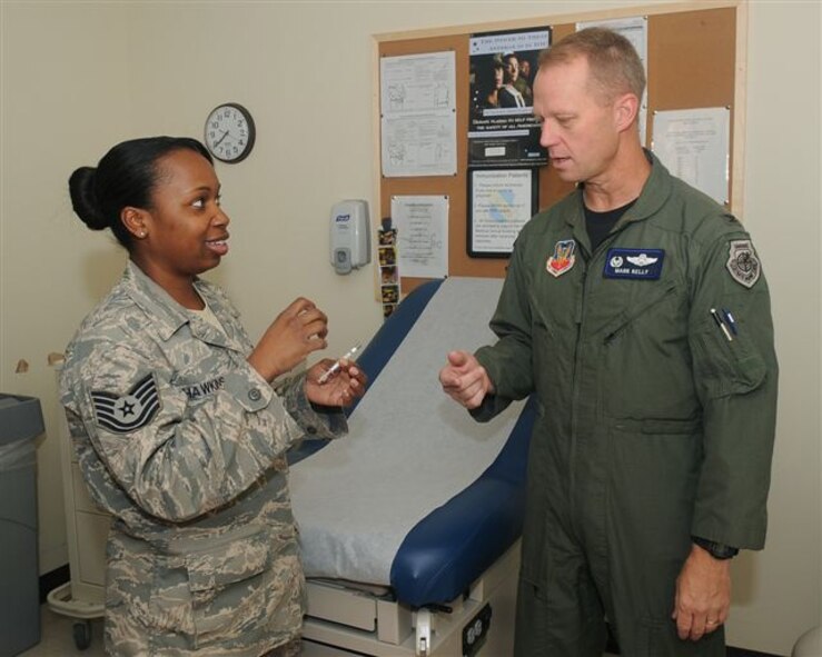Tech Sgt. Patrenia Hawkins, immunization technician, 4th Medical Squadron, speaks with Col Mark Kelly, 4th Fighter Wing Commander, on how to administer the flu mist on Sept. 18, 2008. 