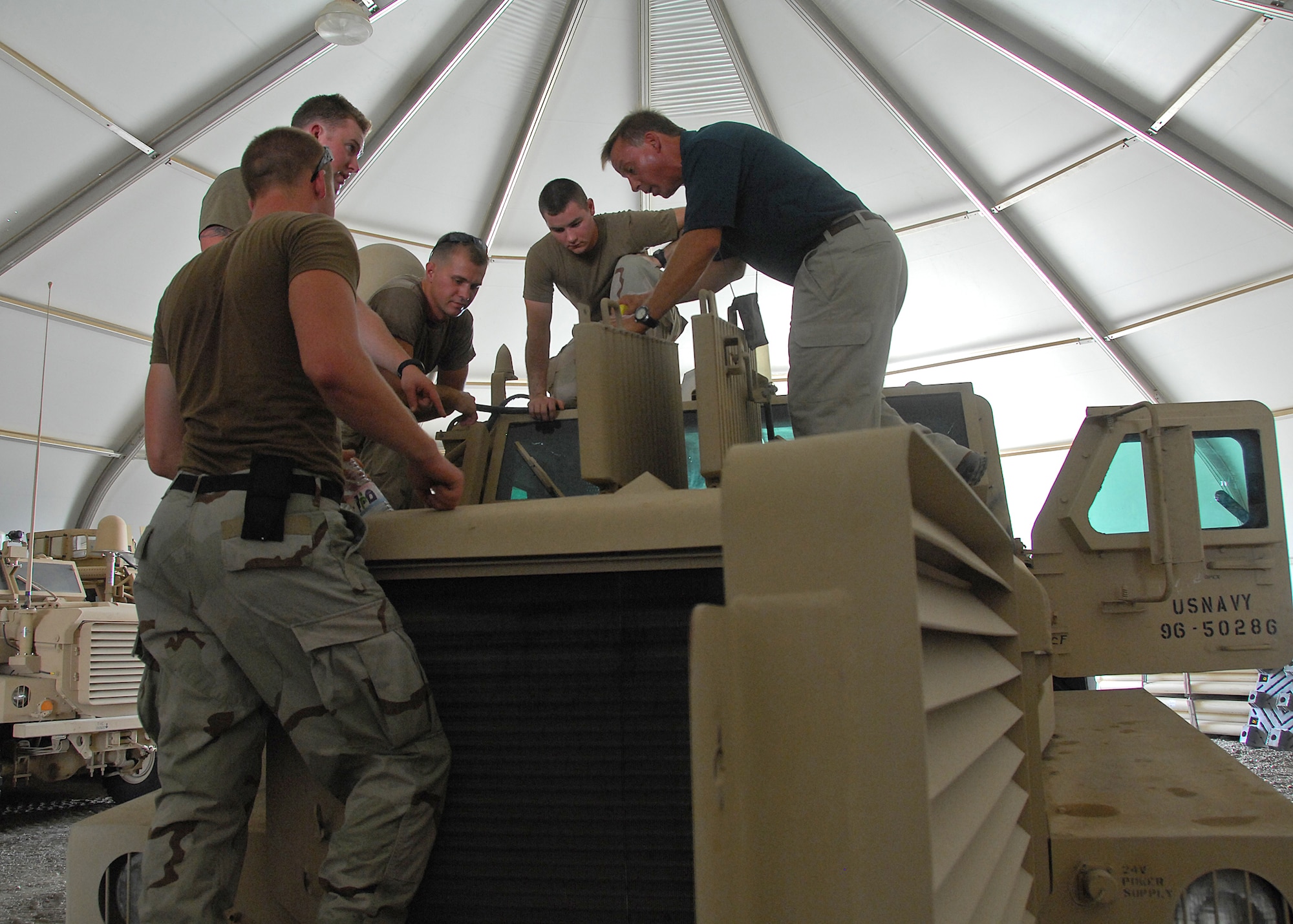 SOUTHWEST ASIA -- Sailors listen intently as Dave Towery, Mine Resistant Ambush Protected Vehicle Cougar series instructor, explains the differences between an MRAP engine and a Humvee engine on Sep. 4 at an air base in Southwest Asia. The MRAP training course is taught in a joint-service environment to simulate real world experiences military members will encounter while deployed to bases in the U.S. Central Command area of responsibility. The Department of Defense has purchased more than 5,200 MRAP vehicles for servicemembers. (U.S. Air Force photo/Tech. Sgt. Raheem Moore)