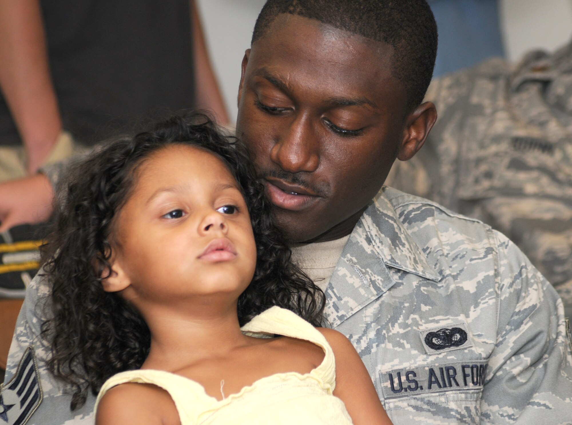 Staff Sgt. Gregory Anderson, 81st Security Forces Squadron, cuddles his 4-year-old daughter, Ariana, at the deployment facility Sept. 9.  Sergeant Anderson and his wife, Amanda, have two other daughters — Mylah, 3, and Jazmin, 6 — who were on hand to tell their daddy goodbye as he departed for Southwest Asia with 46 other Keesler members.  (U.S. Air Force photo by Kemberly Groue)