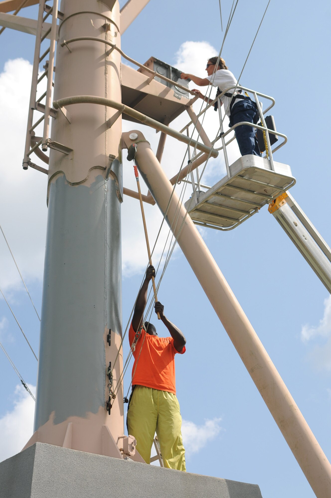 Harris, left, and Simmons paint the mast at the Mississippi Vietnam Veterans Memorial.  (U.S. Air Force photo by Kemberly Groue)