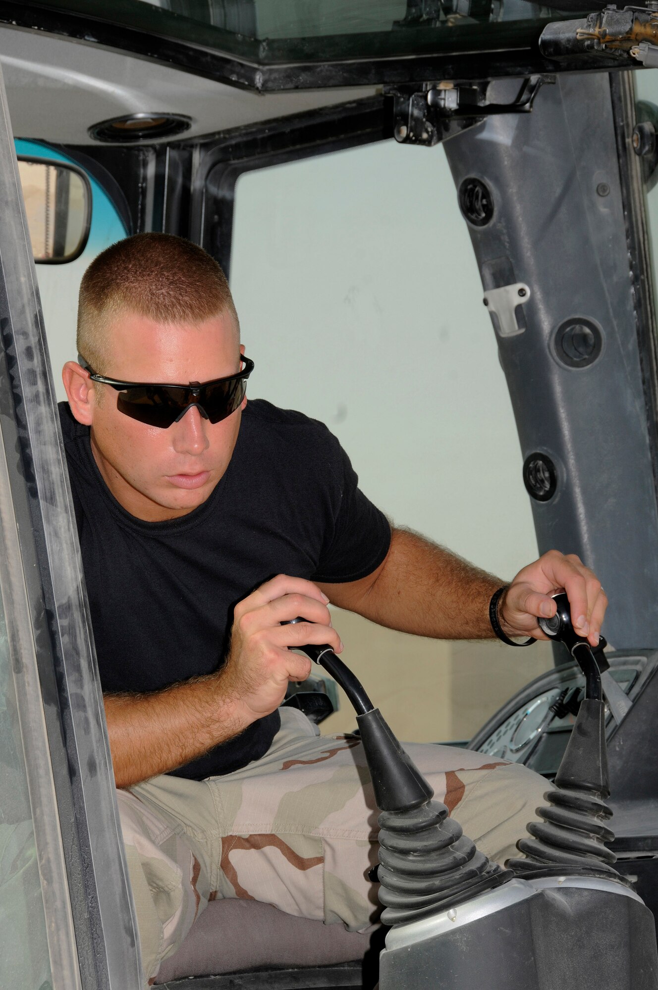 Staff Sgt. David Bengate, 379th Expeditionary Civil Engineer Squadron, carefully operates a backhoe to clear dirt from around a broken section of water main Sept. 15, 2008.  The broken pipe led to a shut down of water in all of the Blatchford-Preston Complex at an undisclosed air base in Southwest Asia.  Sergeant Bengate, a native of Cadillac, Mich., is deployed from McConnell Air Force Base, Kan., supporting Operations Iraqi and Enduring Freedom and Joint Task Force-Horn of Africa.  (U.S. Air Force photo by Tech. Sgt. Michael Boquette/Released)