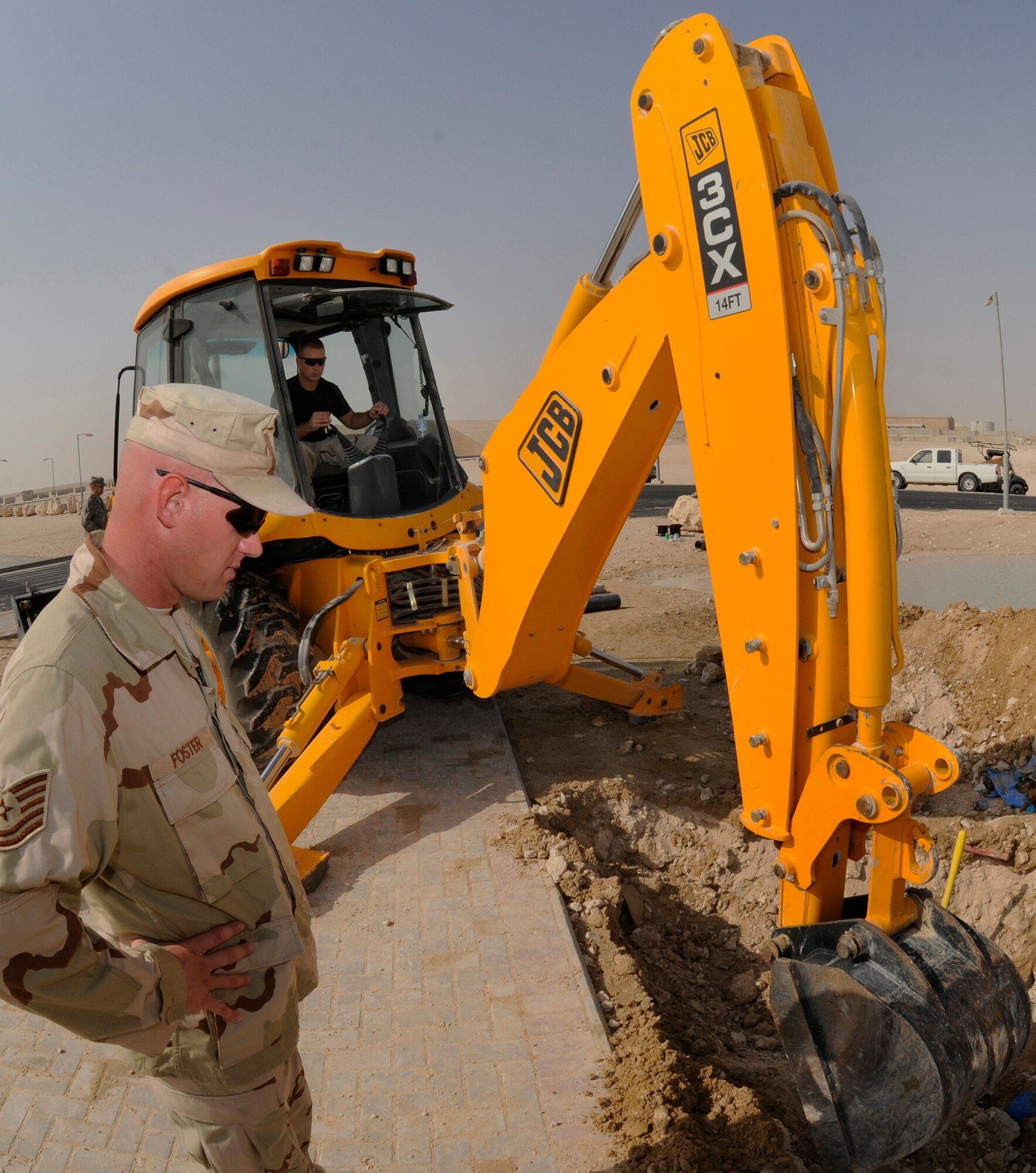 Tech. Sgt. Jason Foster provides an extra set of eyes for Staff Sgt. David Bengate, who operates the backhoe, clearing dirt from a broken section of water main Sept. 15, 2008.  The broken pipe caused a loss of water for the entire Blatchford-Preston Complex at this undisclosed air base in Southwest Asia.  Sergeant Foster hails from Perrysburg, Ohio and is deployed from Scott Air Force Base, Ill. Sgt. Bengate, a native of Cadillac, Mich., is deployed from McConnell AFB, Kan.  Both are assigned to the 379th Expeditionary Civil Engineer Squadron supporting Operations Iraqi and Enduring Freedom and Joint Task Force-Horn of Africa.  (U.S. Air Force photo by Tech. Sgt. Michael Boquette/Released)