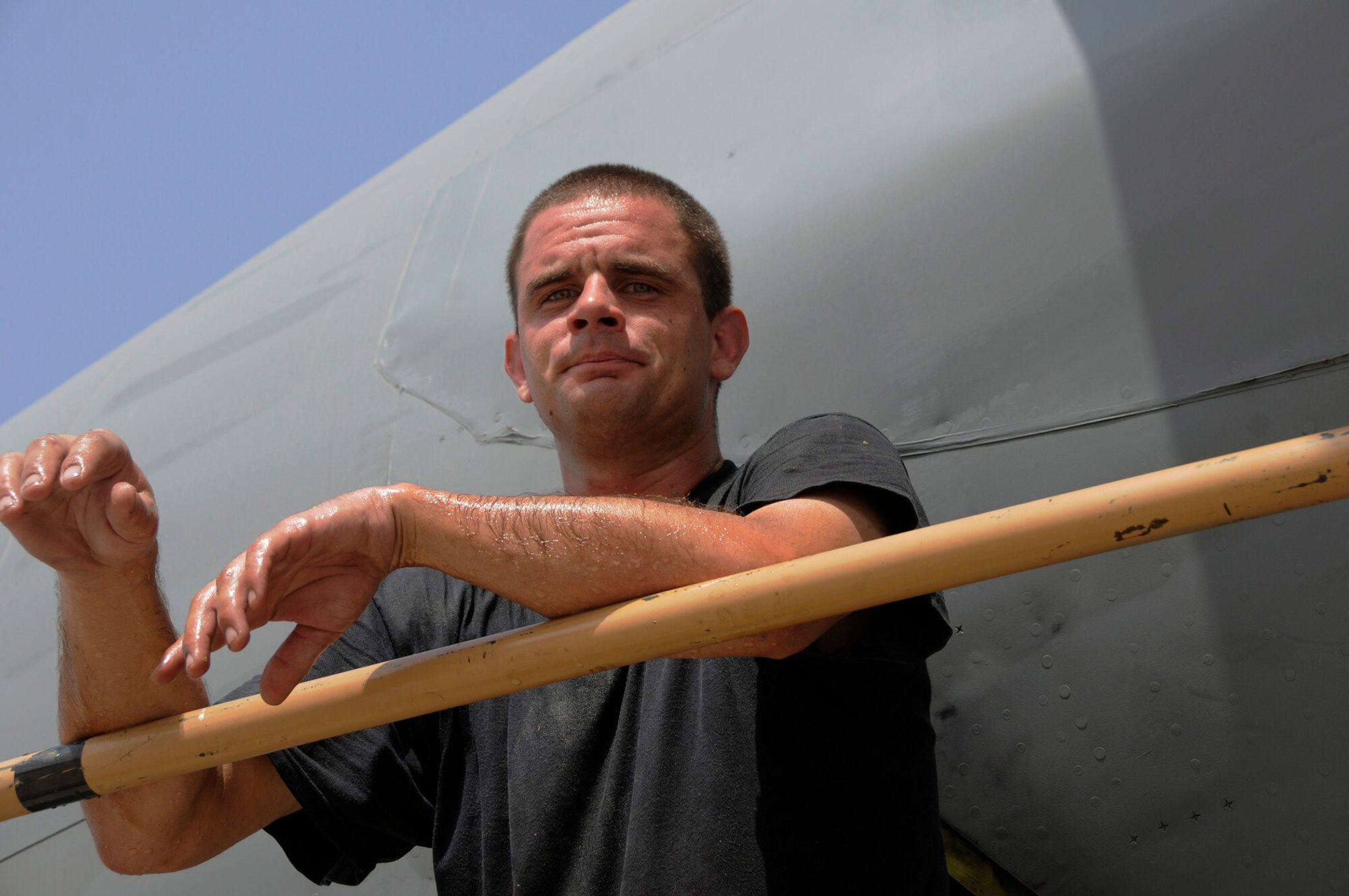 Staff Sgt. Chris Glaab, 379th Expeditionary Aircraft Maintenance Squadron, 340th Aircraft Maintenance Unit, takes a break outside the aircraft to cool his core temperature down Sept. 14, 2008.  His skin is coated in a combination of sweat and hydraulic fluid.  Sergeant Glaab was working in a tiny access compartment in the rear of a KC-135 Stratotanker, trying to track down and fix a hydraulic leak here at this undisclosed desert air base in Southwest Asia.  The KC-135 Stratotanker provides the core aerial refueling capability for Air Force, Navy, Marine Corps and allied nation aircraft supporting Operations Iraqi and Enduring Freedom and Joint Task Force-Horn of Africa.  Sgt. Glaab hails from Altus, Okla., and is deployed from McConnell Air Force Base, Kan.  (U.S. Air Force photo by Tech. Sgt. Michael Boquette/Released)