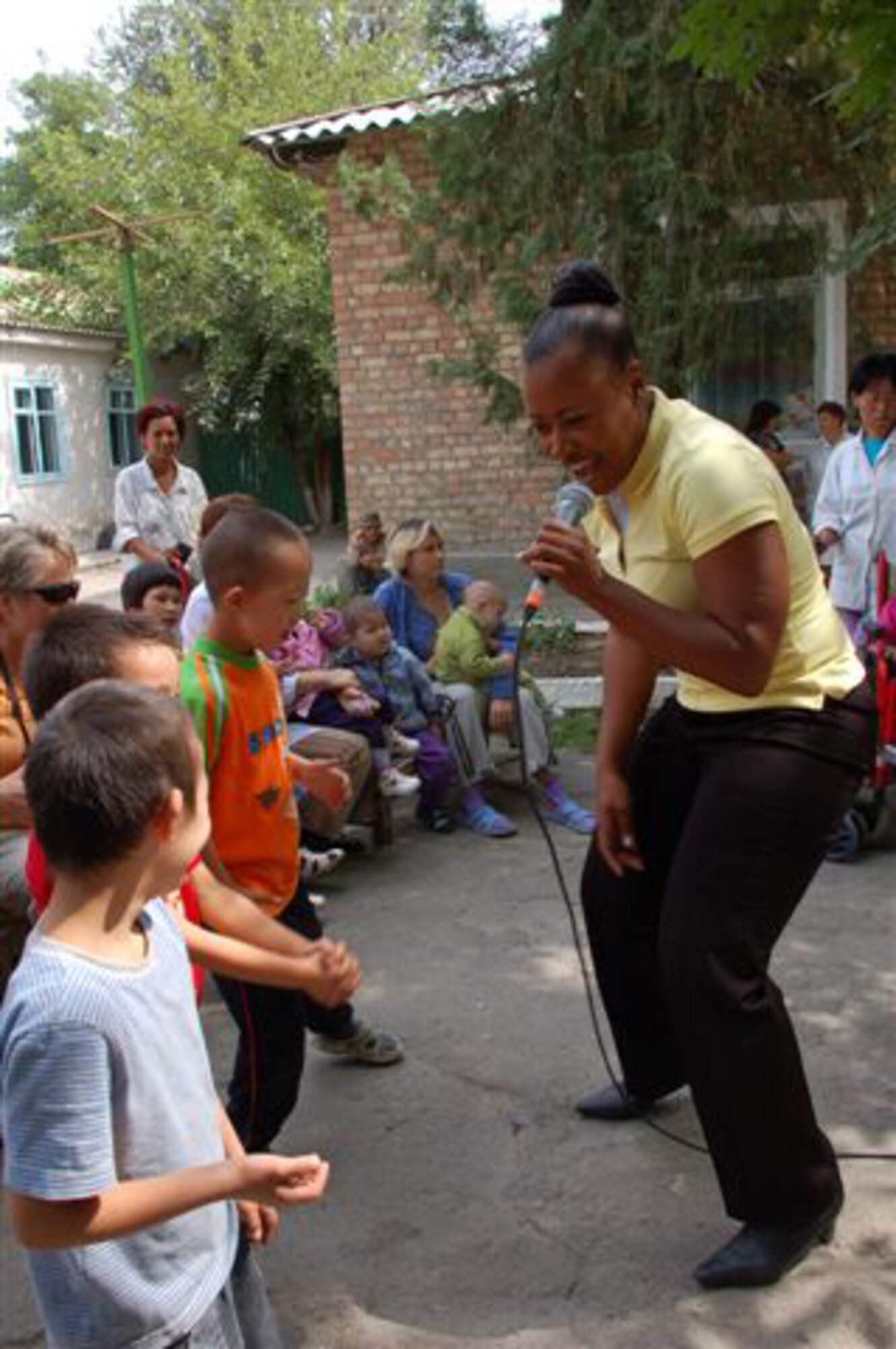 MANAS AIR BASE, KRYGYZ REPUBLIC - Master Sgt. Regina Coonrod sings to young Kyrgyz boys during a visit to the Tok Mok II Boarding School in the Kyrgyz Republic. The U.S. Air Forces Central Band "Yuma" performed there Sept. 5 during their eight day tour at Manas AB. They played at six schools, villages and orphanages for hundreds of Kyrygz children and also performed on base for servicemembers deployed or transiting through Manas. (Air Force photo / Major Damien Pickart)