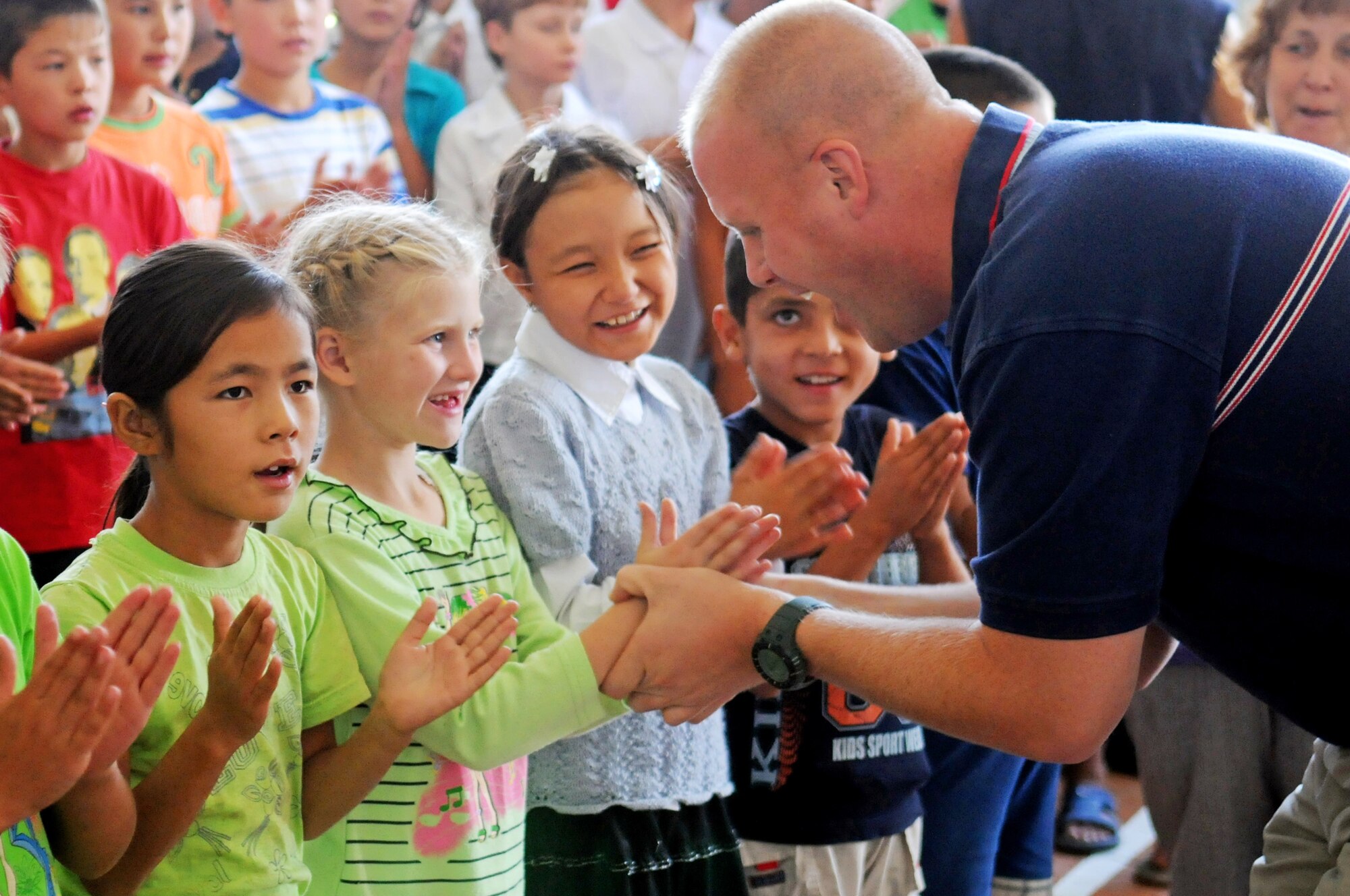MANAS AIR BASE, KYRGYZ REPUBLIC - Master Sgt. Ryan Carson sings and interacts with a young Kyrgyz fan at the Bishkek School for the Deaf. During their eight day tour at Manas, the U.S. Air Forces Central Band "Yuma" performed ten concerts at local schools, villages and orphanages, as well as on base for coalition servicemembers. (Air Force photo / Tech. Sgt. Michael Voss)