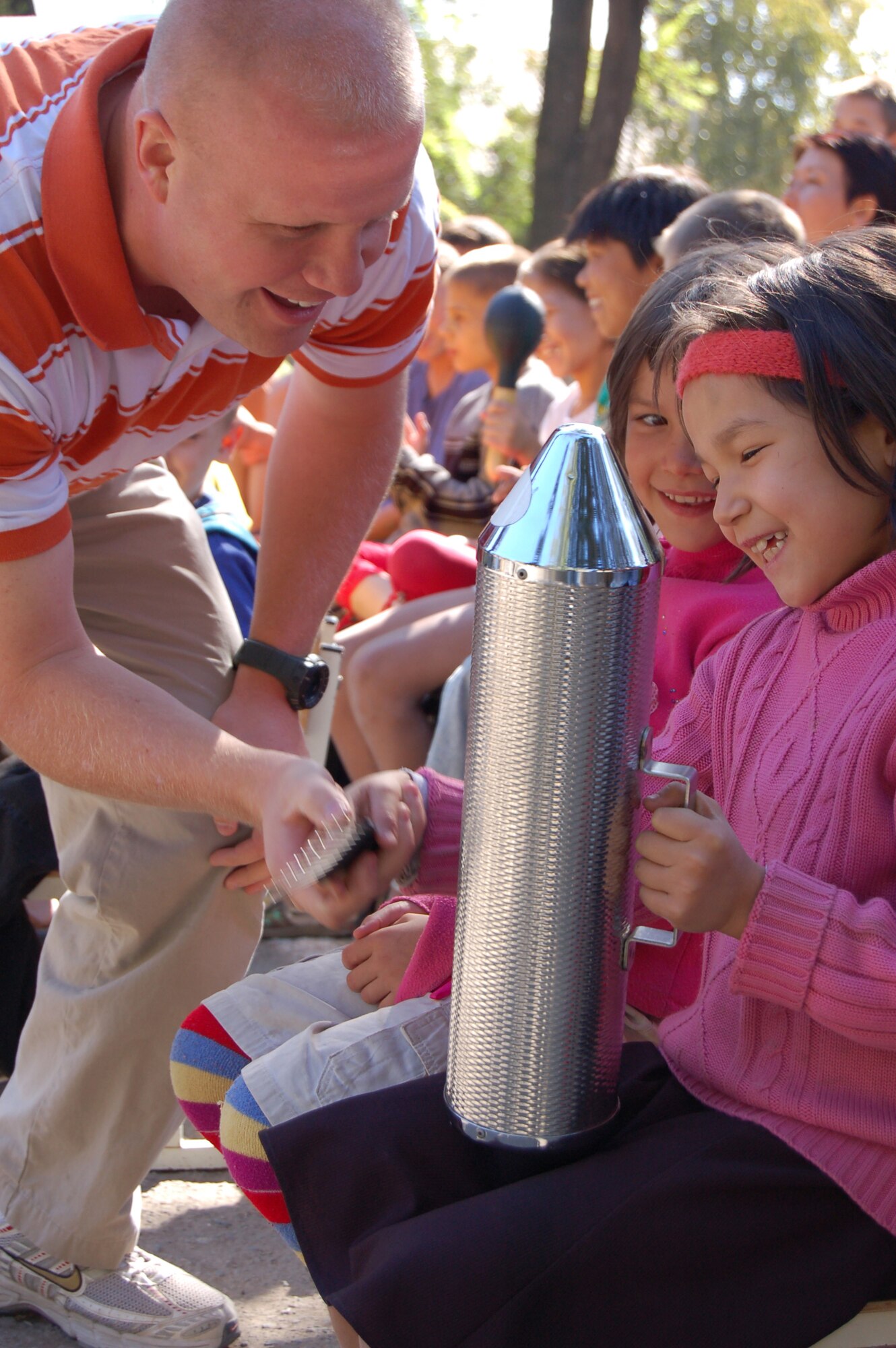 Master Sgt. Ryan Carson shows an excited young Kyrgyz girl how to play an instrument during a visit to the Voenno Antonovka orphanage in the Kyrgyz Republic.  The U.S. Air Force central Band "Yuma" performed there Sep. 07, 2008 during their eight day tour at Manas AB, Kyrgyzstan where they played at six schools, villages and orphanages and four on base concerts.  (Air Force photo / Senior Master Sgt. Patrick McCracken)