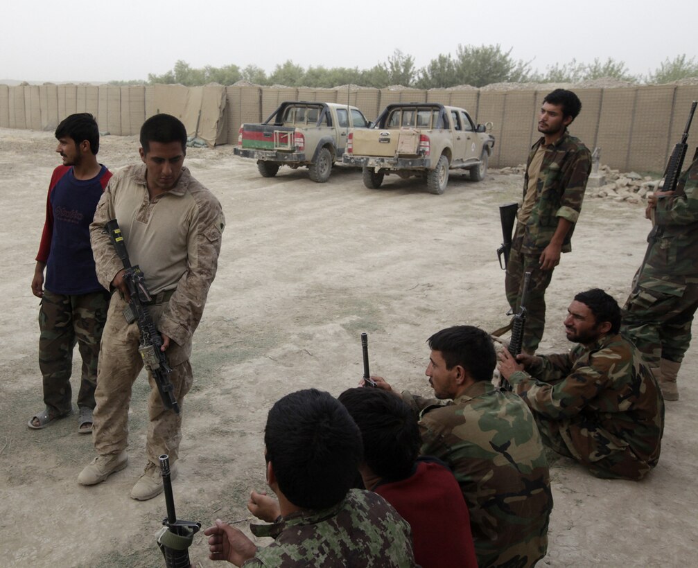 Sergeant Enrique Goveabarragan, a rifleman with Weapons Company, 3rd Battalion, 1st Marine Regiment, speaks with members of the Afghan National Army during a training exercise held at Patrol Base Gorgak, Helmand province, Afghanistan, July 23, 2010.  Building relationships with the ANA makes training and working together easier for both groups.