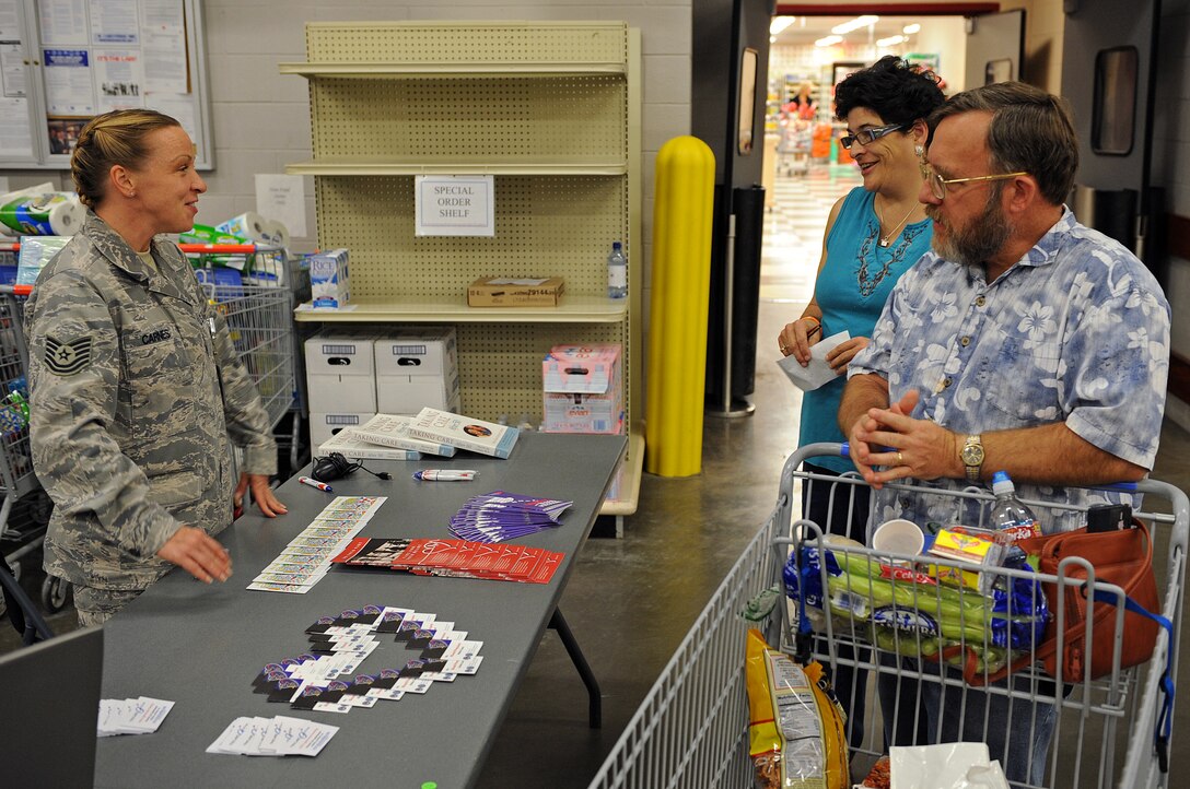 Tech. Sgt. Tricia Carnes, 28th Medical Support Squadron TRICARE Operations Patient Administration Flight NCO in charge, explains how to enroll on TRICARE Online to Gene Billingsley, retired Senior Master Sgt., and his wife Kathy during Retiree Appreciation Day at the commissary, Sept. 19. Mr. Billingsley retired in 2000 after serving for 26 years. (U.S. Air Force photo/Senior Airman Marc I. Lane)
