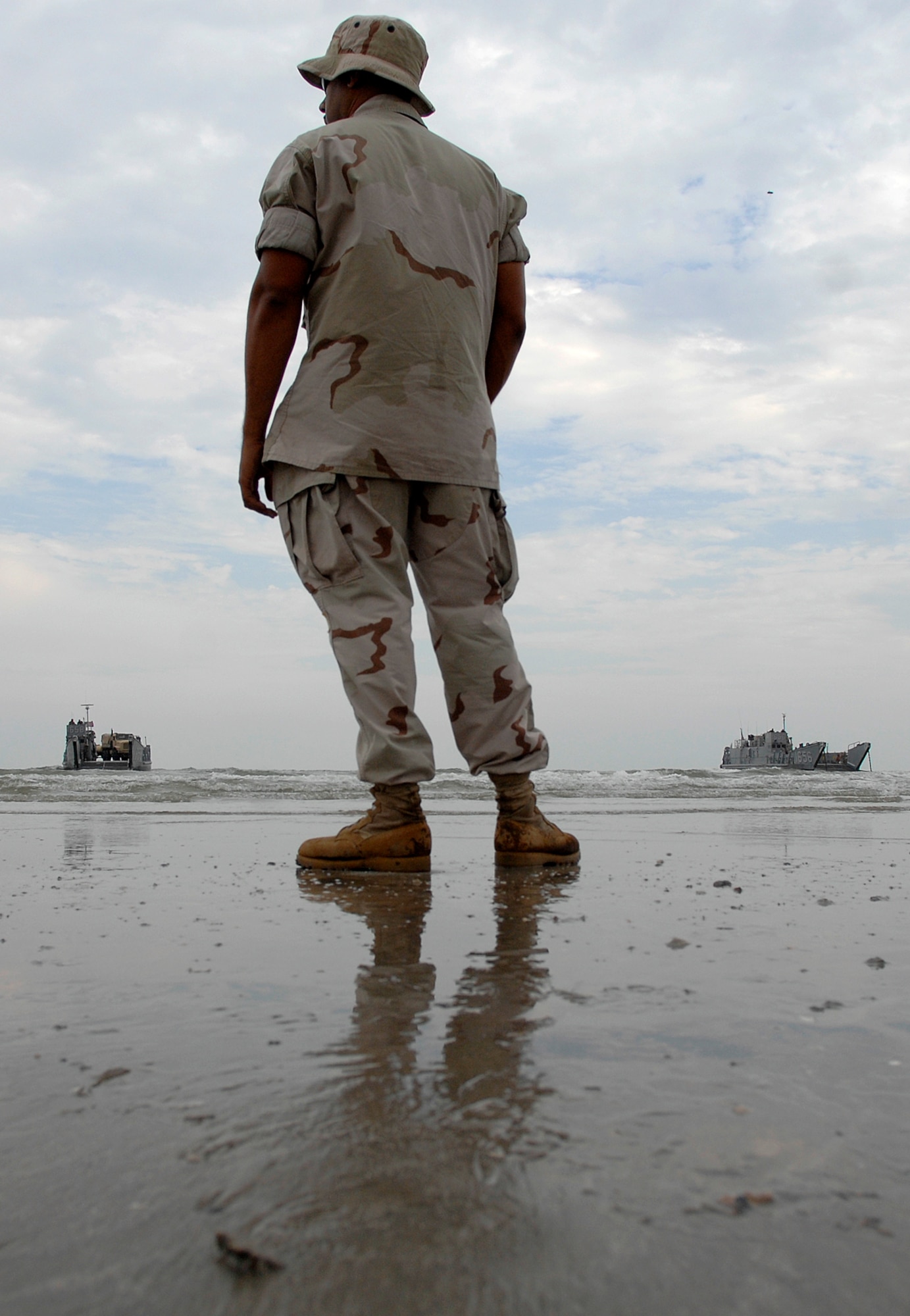 A member of Beachmaster Unit Two directs utility landing crafts from the amphibious assault ship USS Nassau Sept. 18 on the beach near Galveston, Texas to begin disaster relief efforts . The Nassau is anchored off Galveston to provide disaster response and aid to civil authorities as directed in the wake of Hurricane Ike.  (U.S. Air Force photo/Staff Sgt. Bennie J. Davis III)