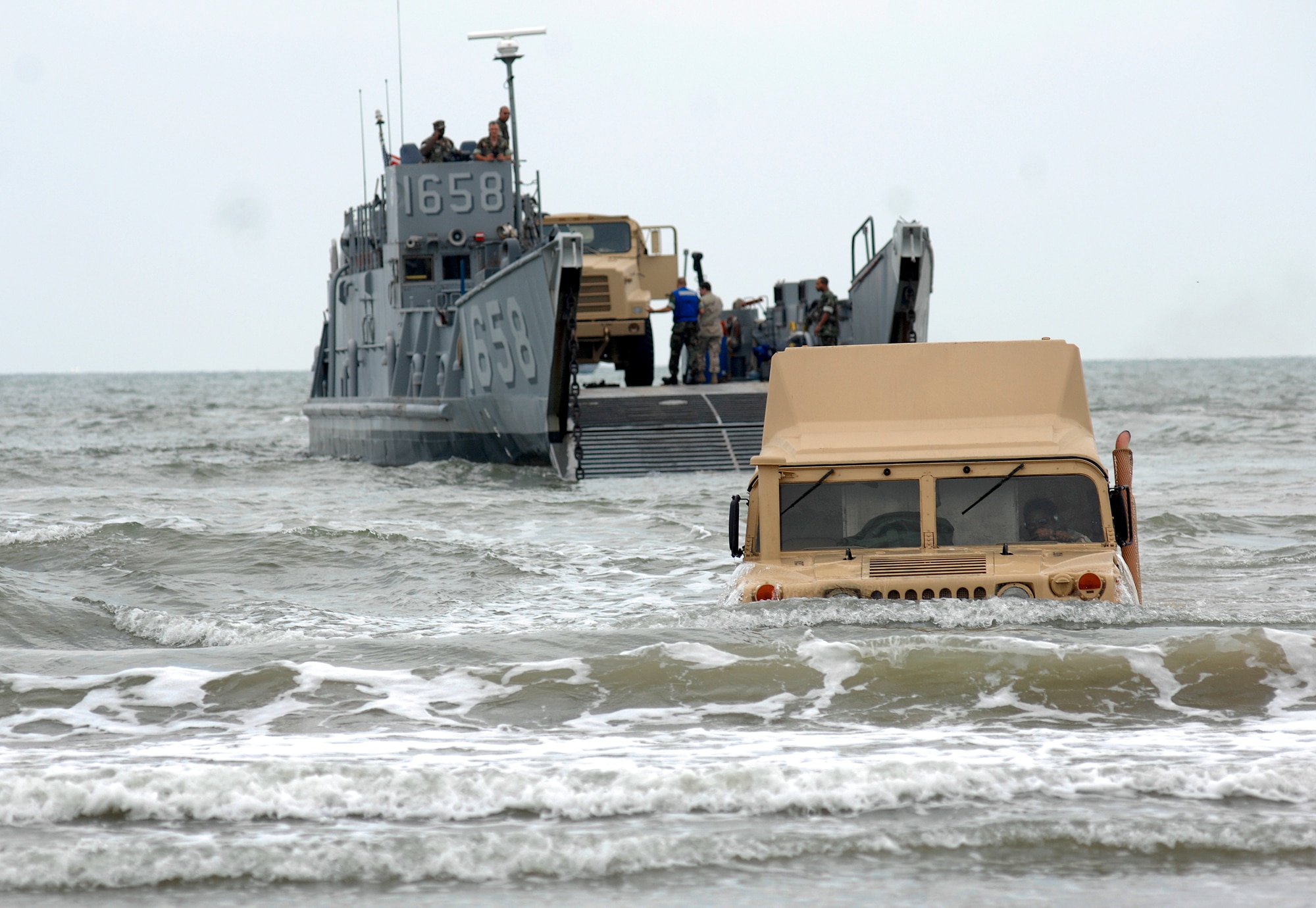 A high mobility multipurpose wheeled vehicle or Humvee exits from an utility landing craft Sept. 18 on the beach near Galveston, Texas. The Humvee was from the amphibious assault ship USS Nassau anchored off Galveston to provide disaster response and aid to civil authorities as directed in the wake of Hurricane Ike.  (U.S. Air Force photo/Staff Sgt. Bennie J. Davis III)